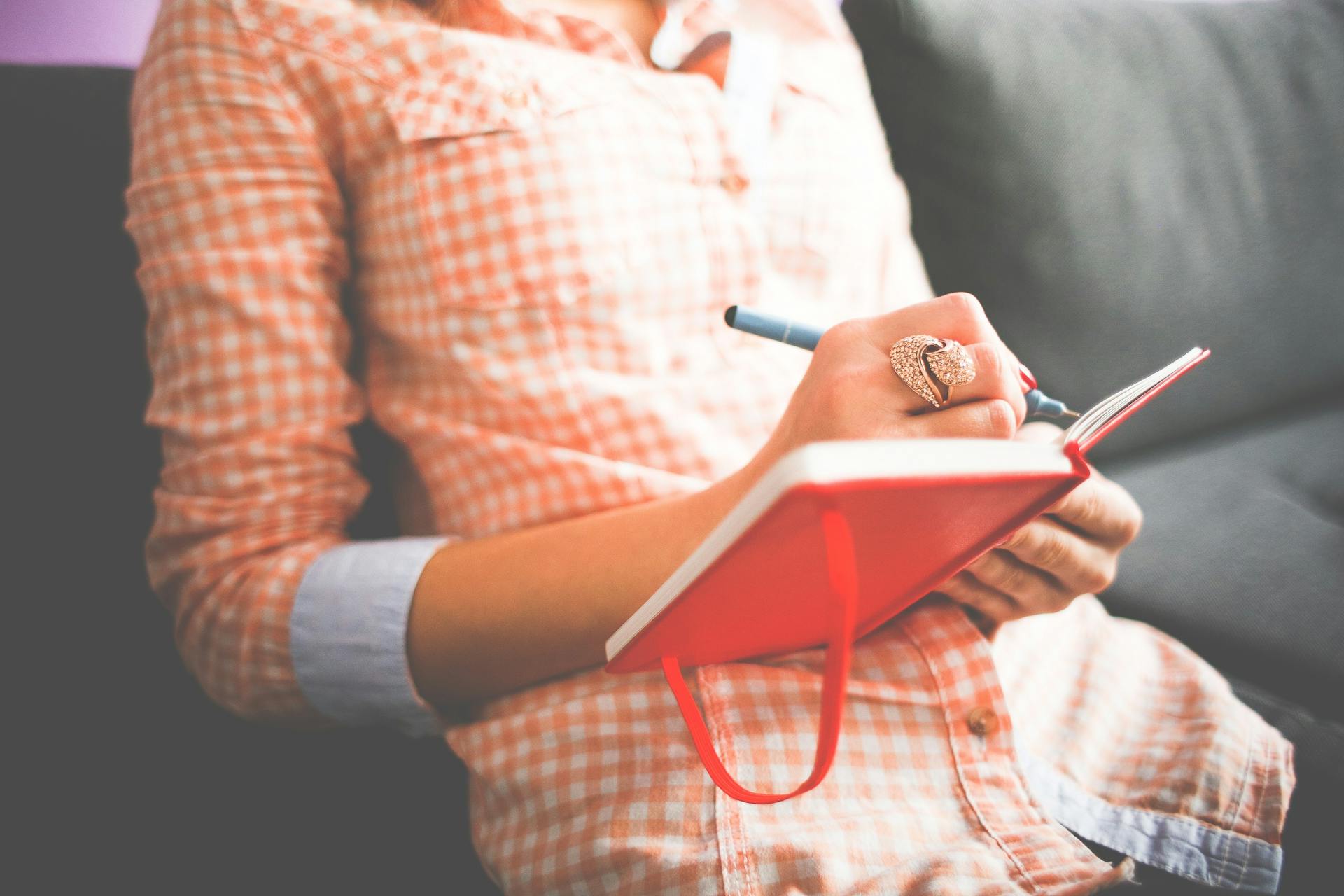 A person writing in a notebook | Source: Pexels