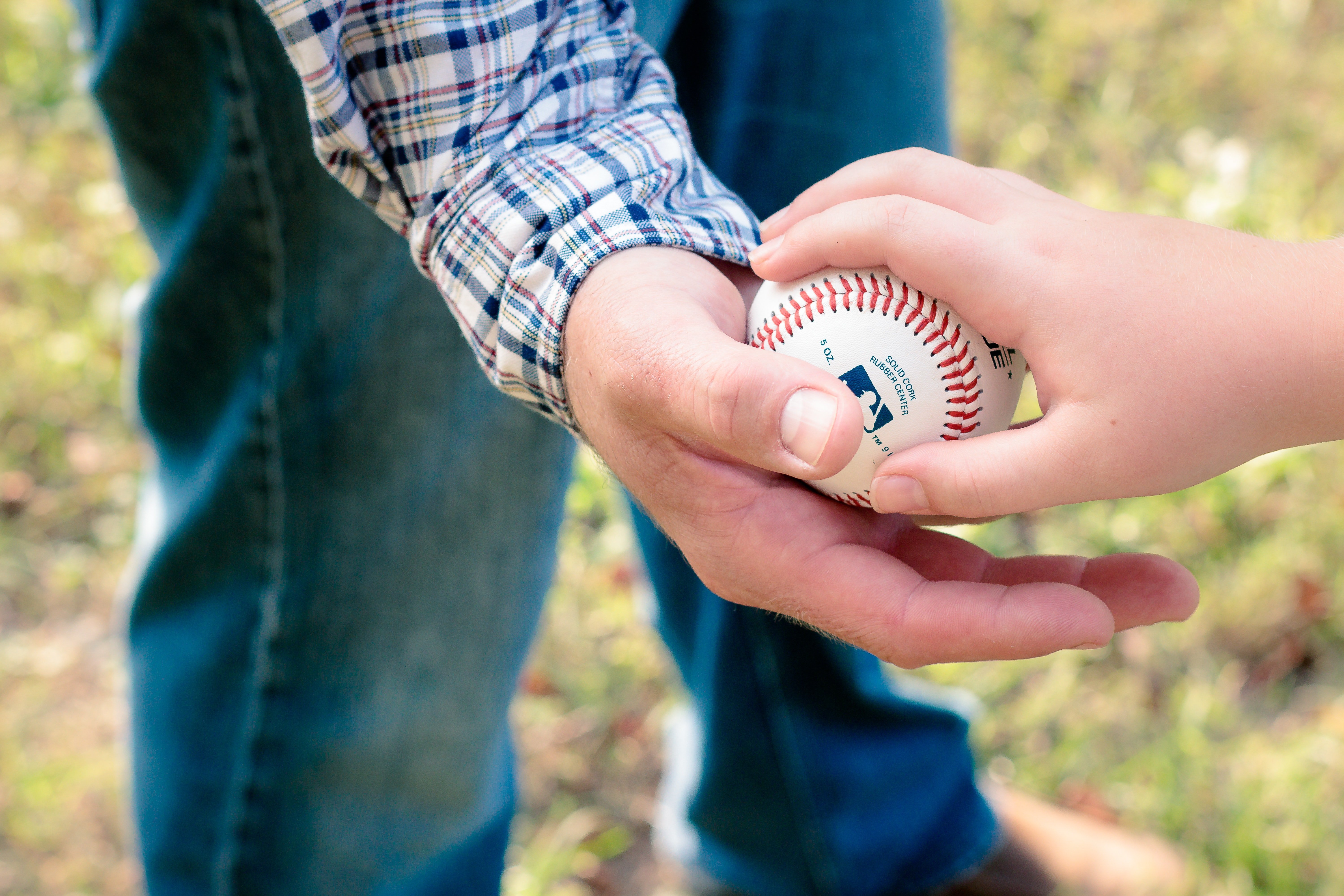 Boy handing over a baseball. | Source: Michael Morse/Pexels