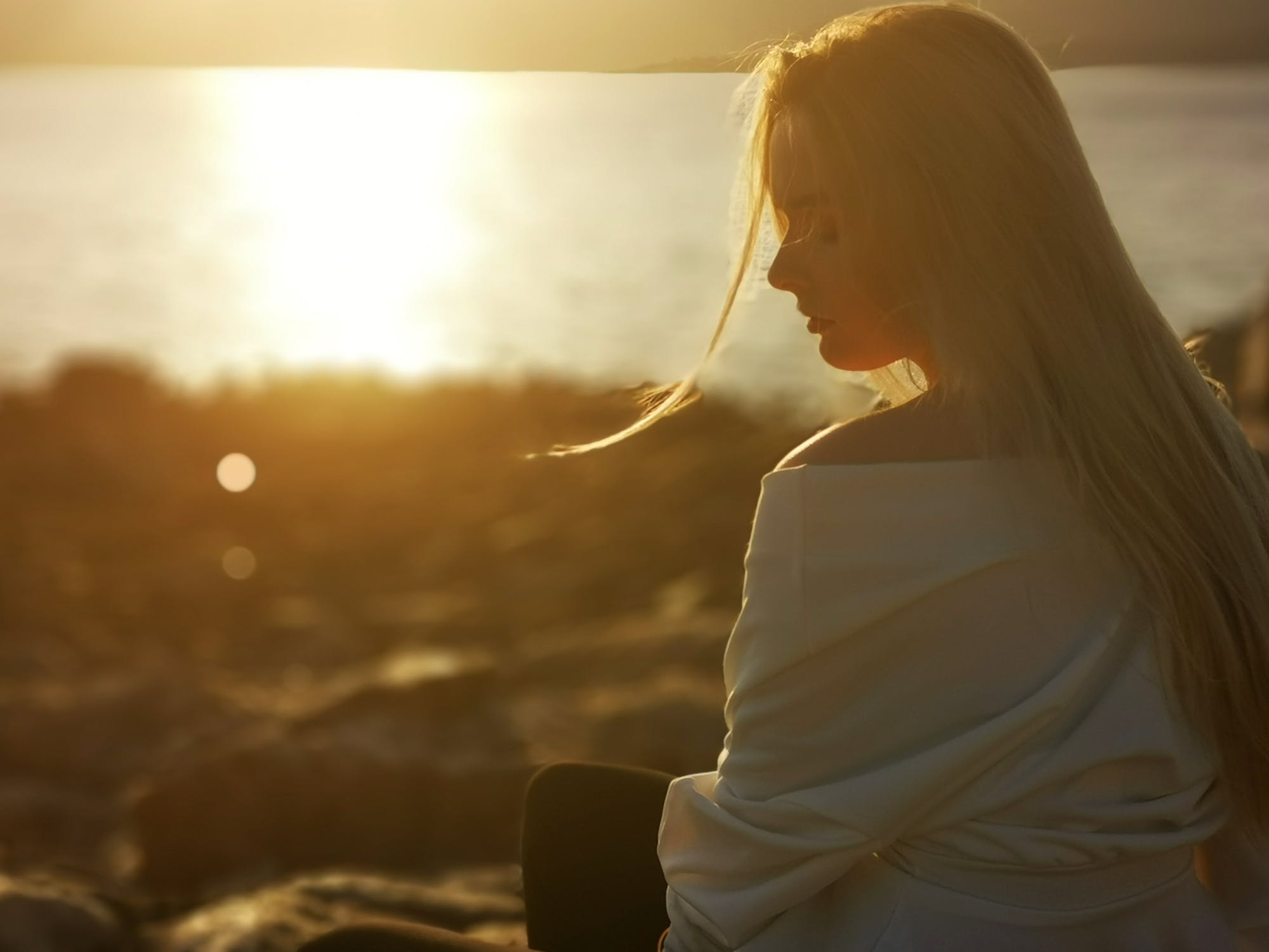 Mujer pensativa observando la puesta de sol. | Imagen: Pexels