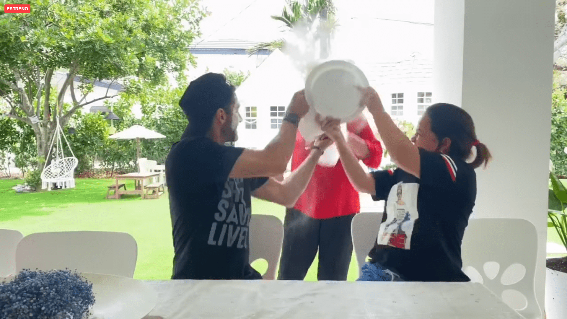Toni Costa y Adamari López lanzan el contenido de los platos de harina a la desprevenida madre de él. | Foto: Facebook/Toni Costa
