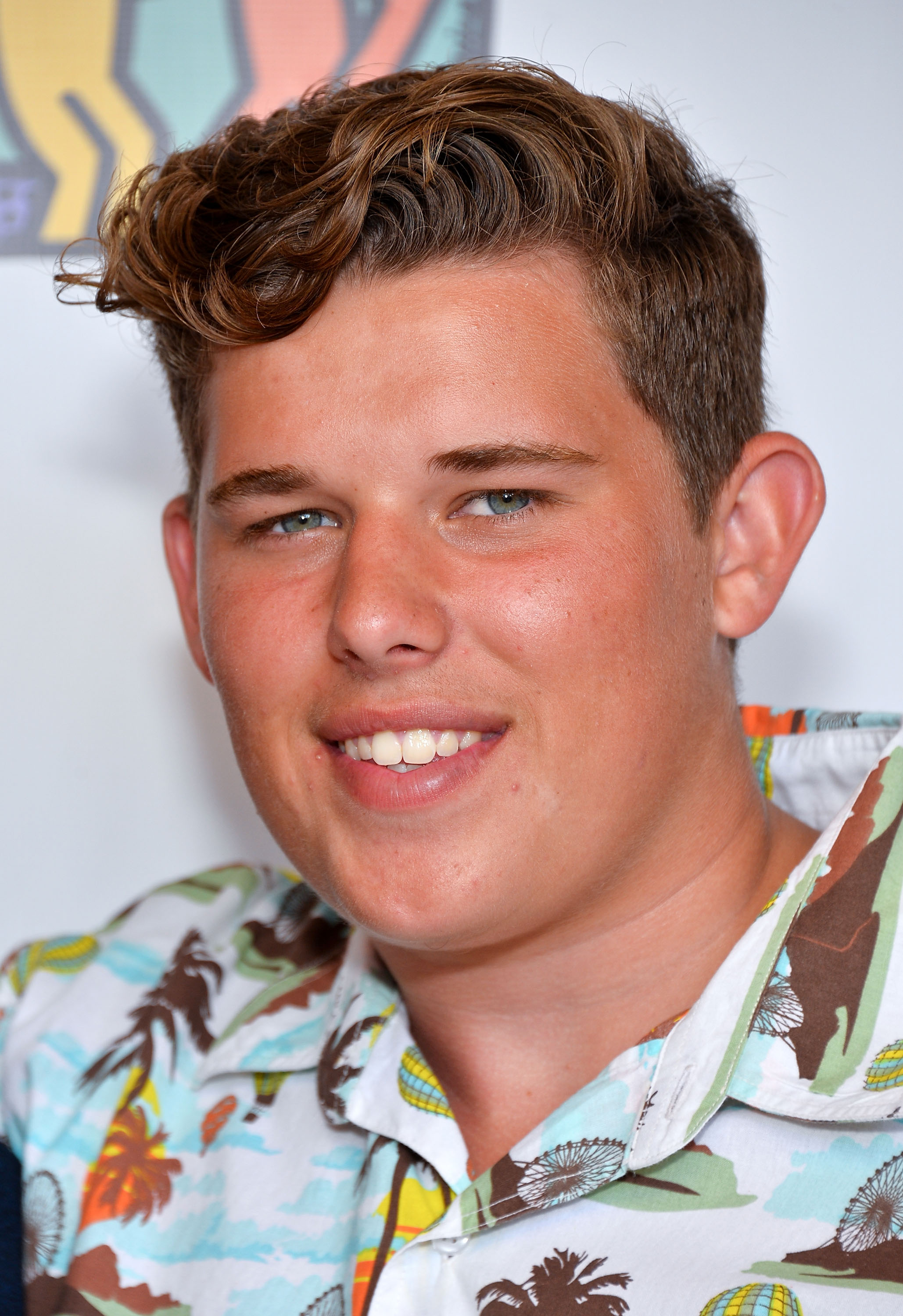 Christopher Schwarzenegger attends the Team Maria benefit for Best Buddies at Montage Beverly Hills on August 18, 2013. He wears a colorful, tropical-print shirt and smiles for the camera, his hair styled in a short, wavy cut.