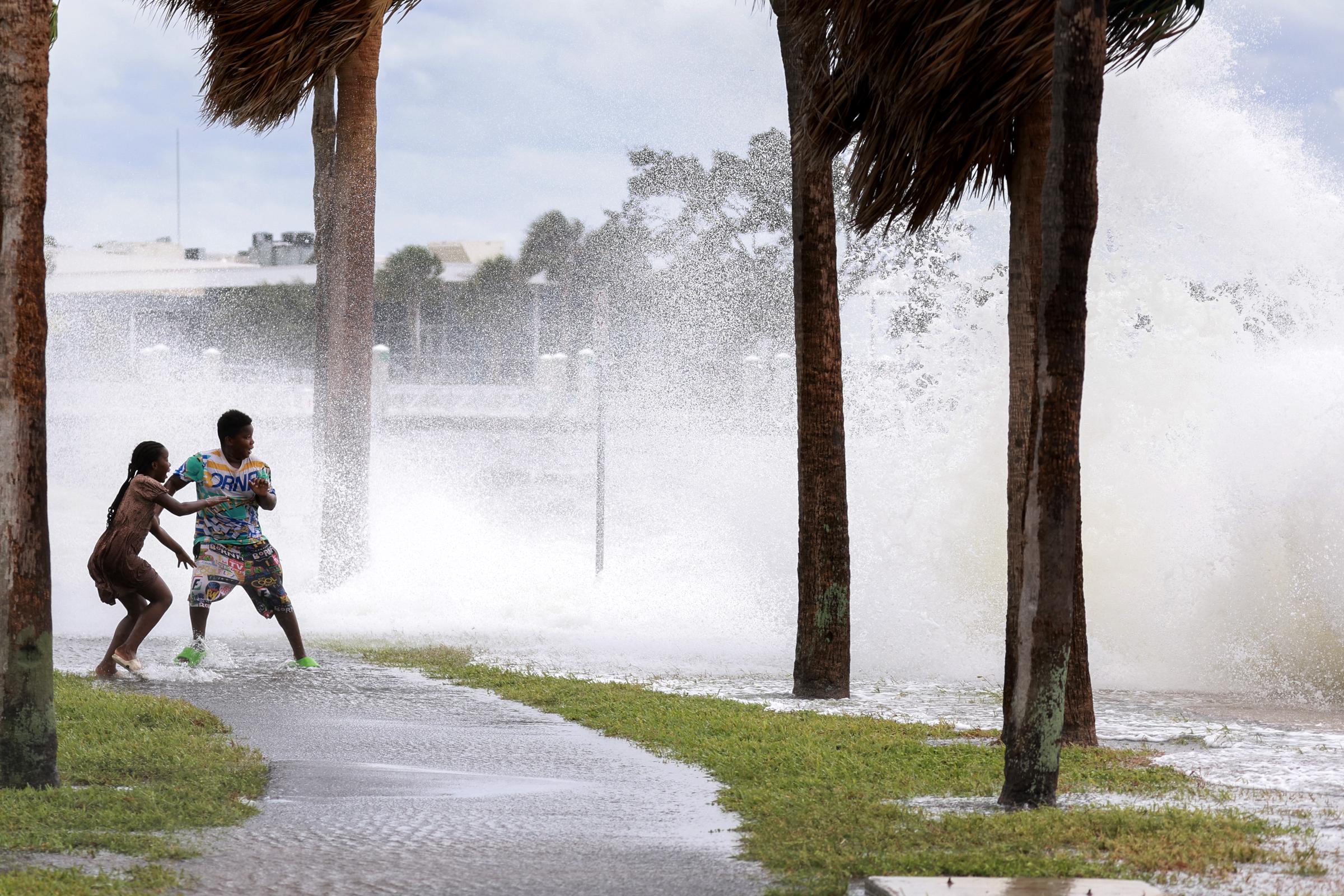 People splashed by a churning wave from Tampa Bay as Hurricane Helene passes offshore in St. Petersburg, Florida on September 26, 2024 | Source: Getty Images