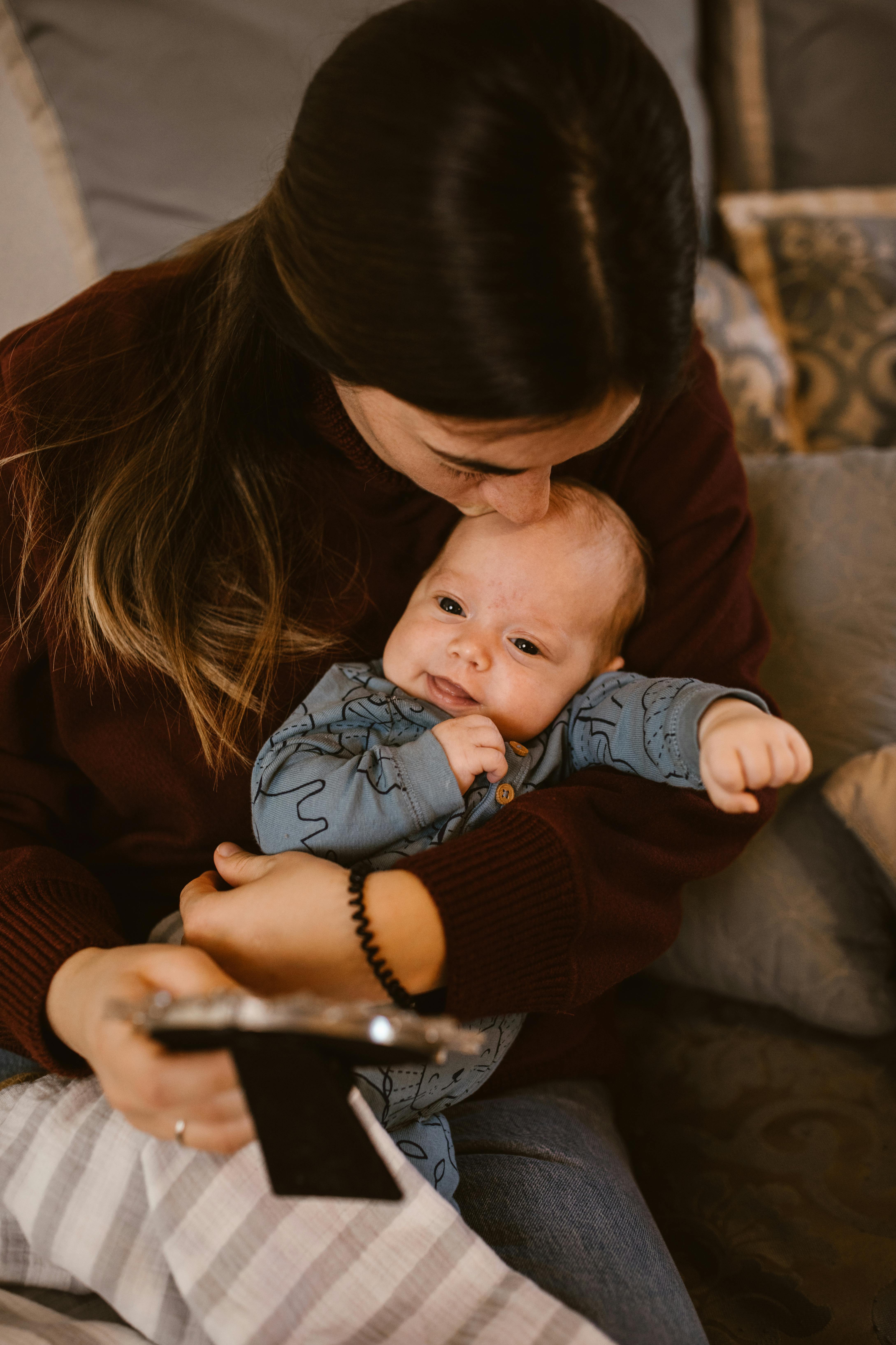 A mother kissing her baby's head | Source: Pexels