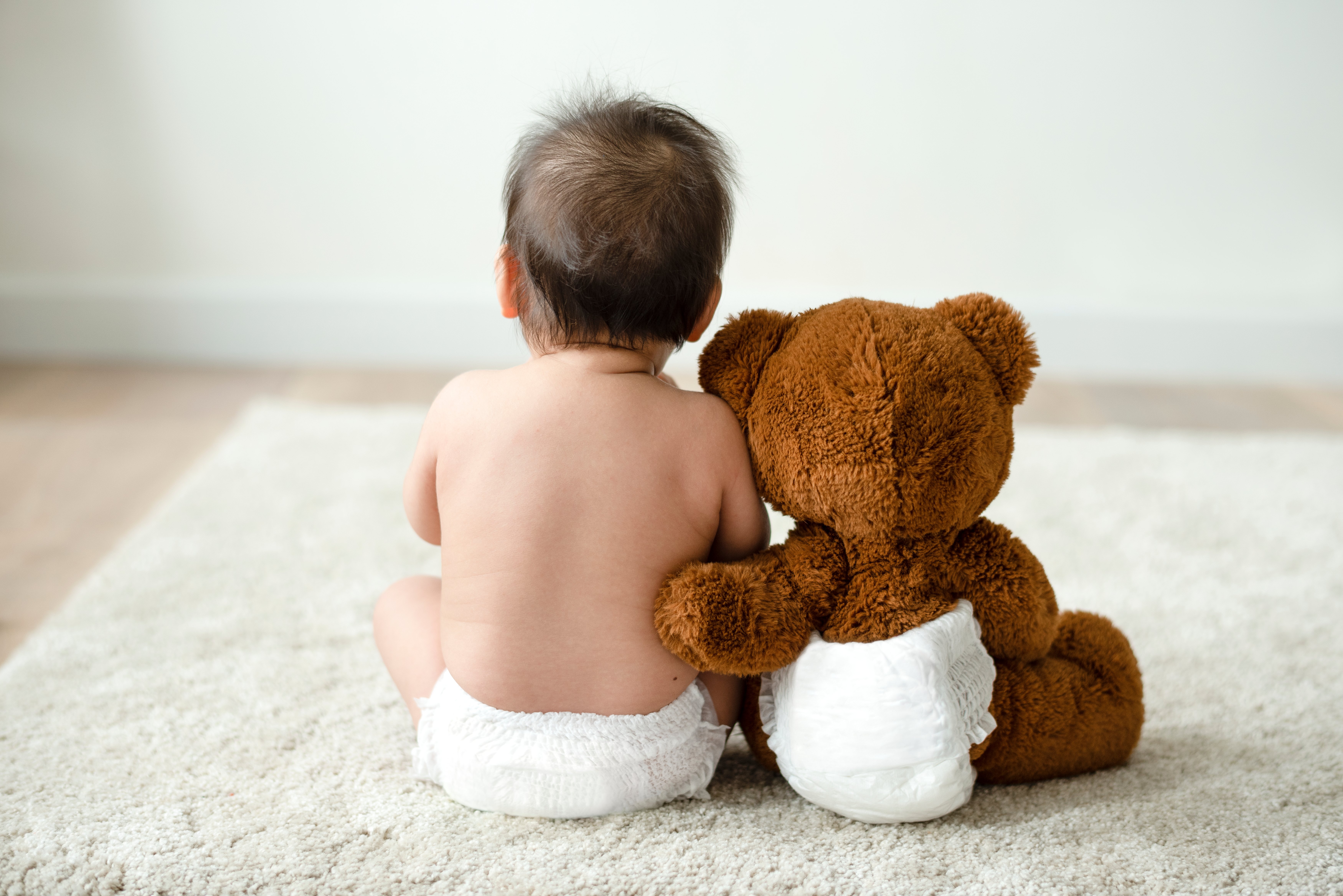 L'enfant assis à côté de son ours en peluche | Photo : Shutterstock