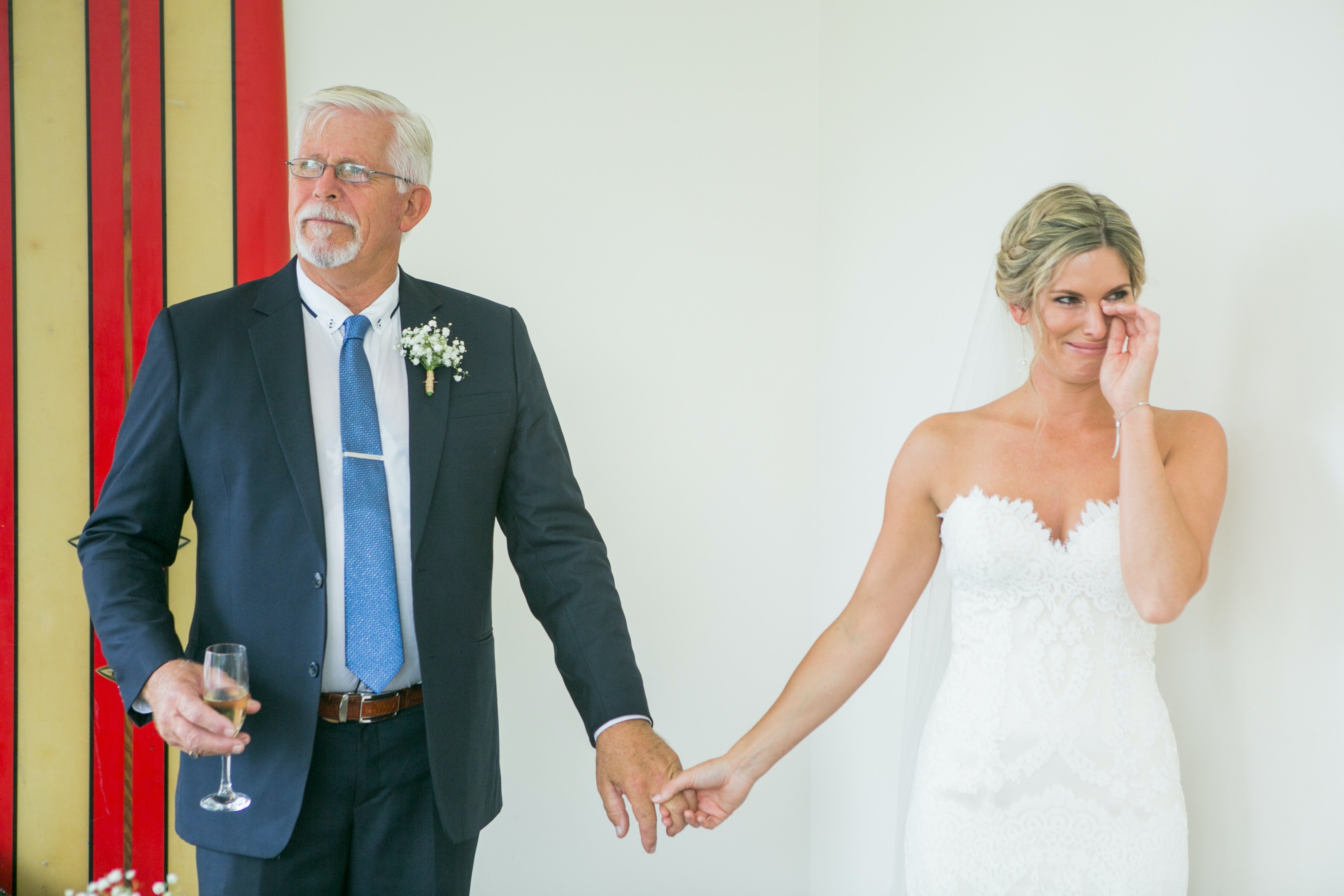 Un hombre mayor vestido de traje y una mujer vestida de novia tomados de la mano. | Foto: Unsplash