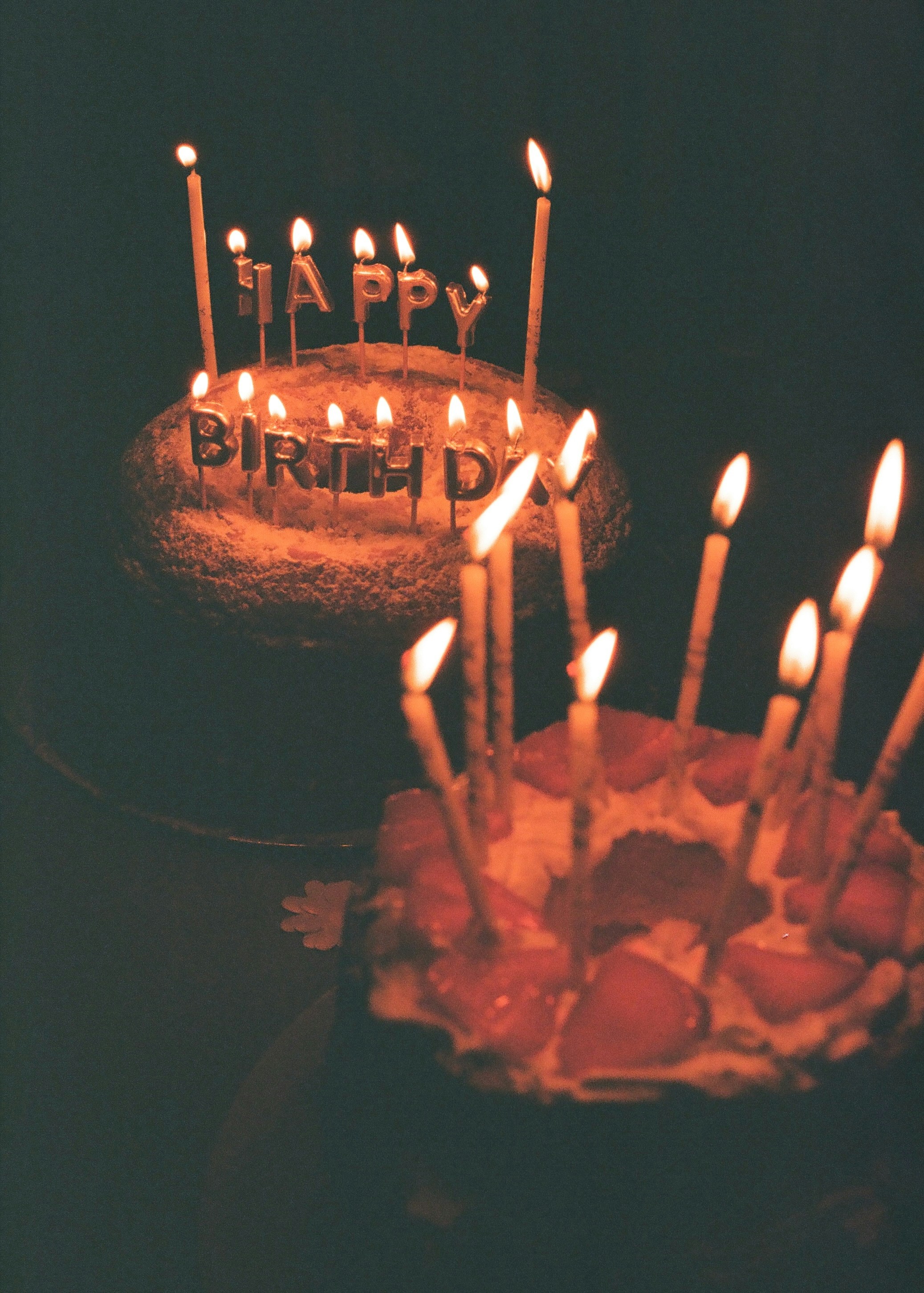 Two birthday cakes with candles | Source: Unsplash