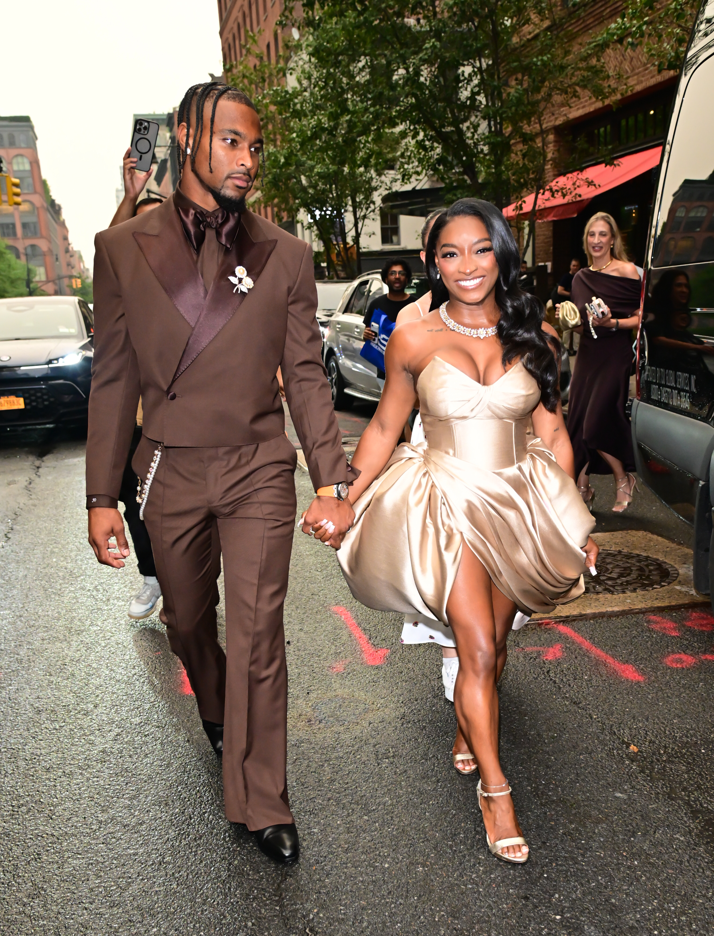 Away from the backdrop, the couple's coordinated outfits remained just as striking as they walked through New York City hand in hand. The candid image offered a different perspective from the red carpet and showed the pair interacting beyond the brief viral clip. | Source: Getty Images