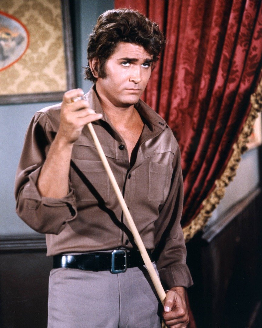 Michael Landon wearing a brown shirt and grey trousers, chalking a pool cue, in a publicity portrait issued for the US television series, 'Bonanza', USA, circa 1970. | Source: Getty Images