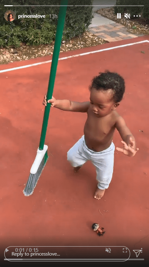 A screenshot from a clip of Princess Love's son Epik playing outdoors and holding a broom. | Photo: Instagram/Princesslove