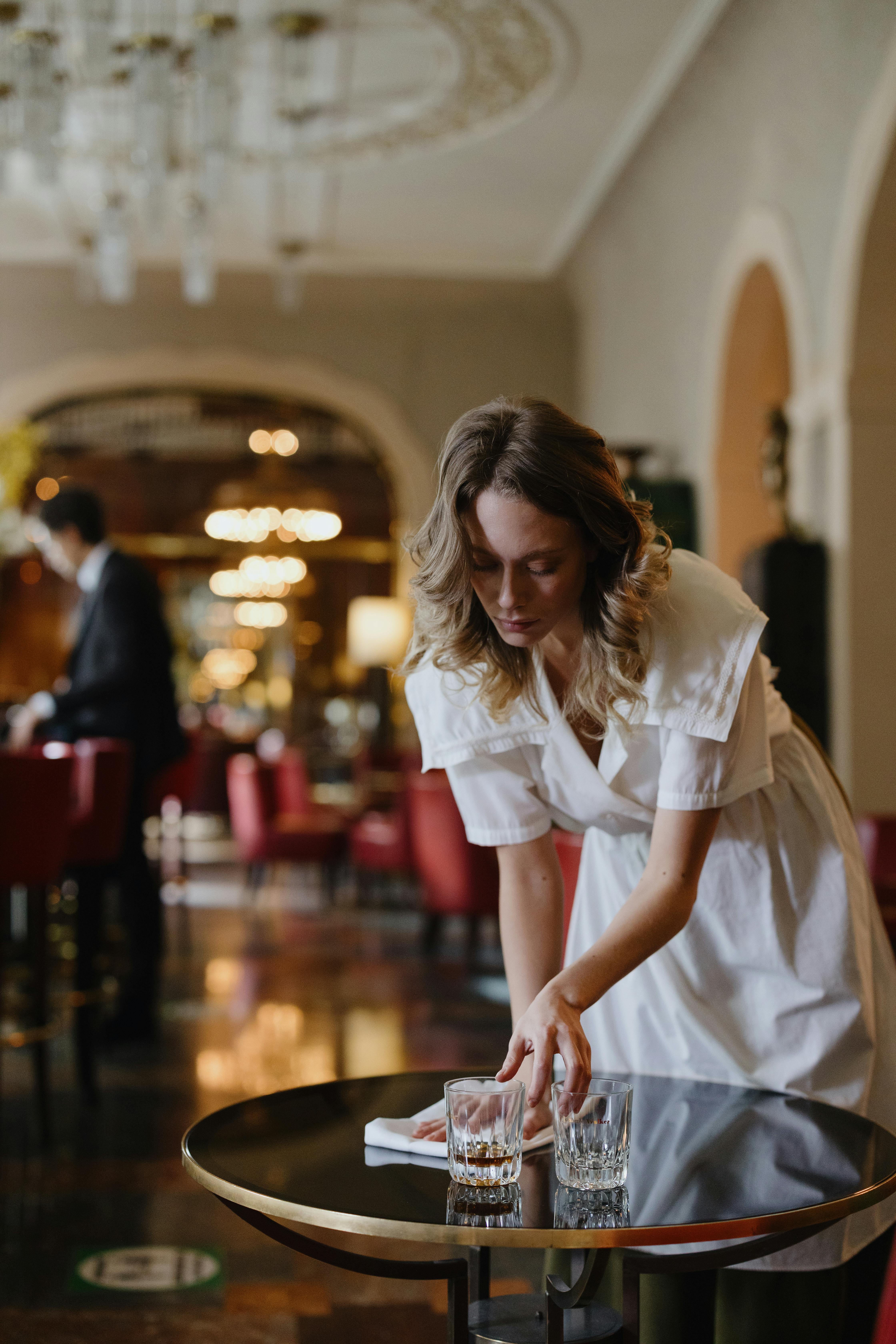 A woman wiping down a restaurant table | Source: Pexels