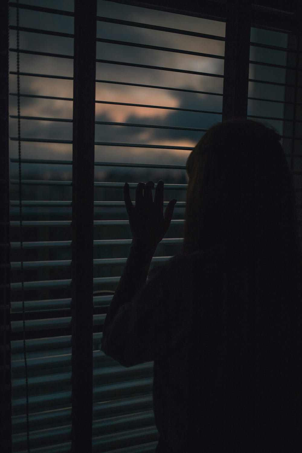 Mujer observando por la ventana. | Imagen: Pexels