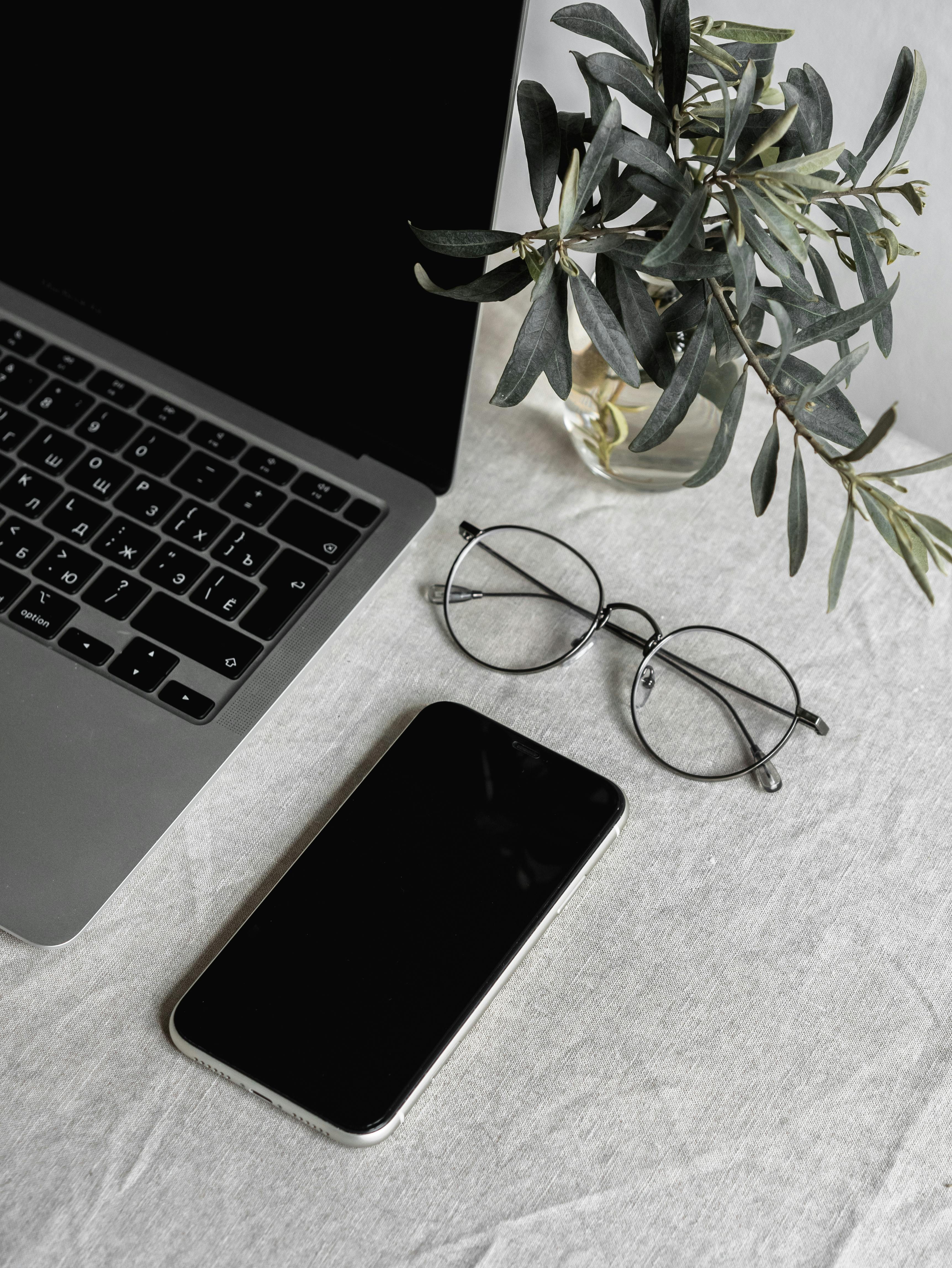 A cellphone, glasses, and laptop on a table | Source: Pexels