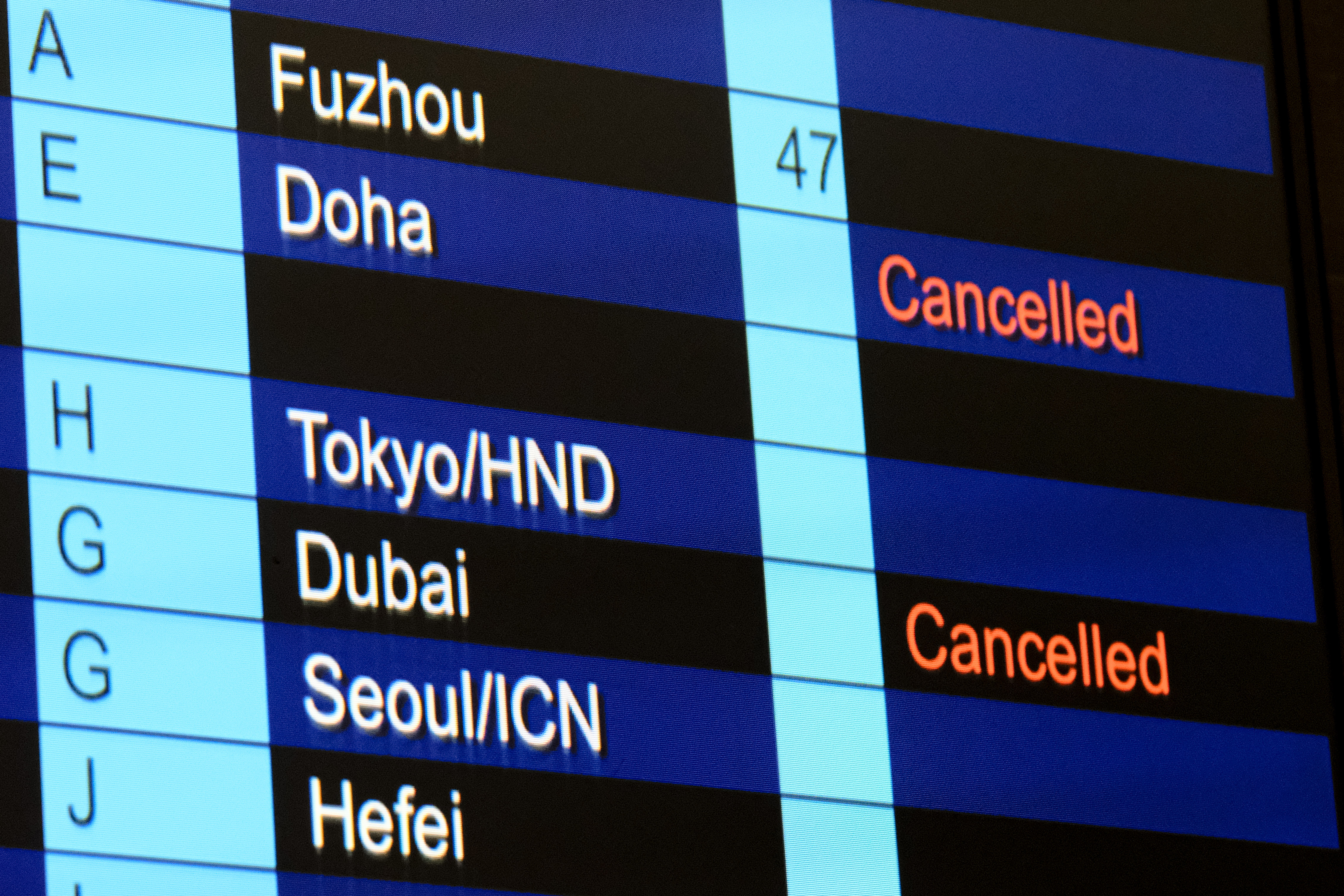Cancelled flights to Dubai and Doha shown on flight information display at Hong Kong International Airport on 2 March 2026 in Hong Kong, China. | Source: Getty Images
