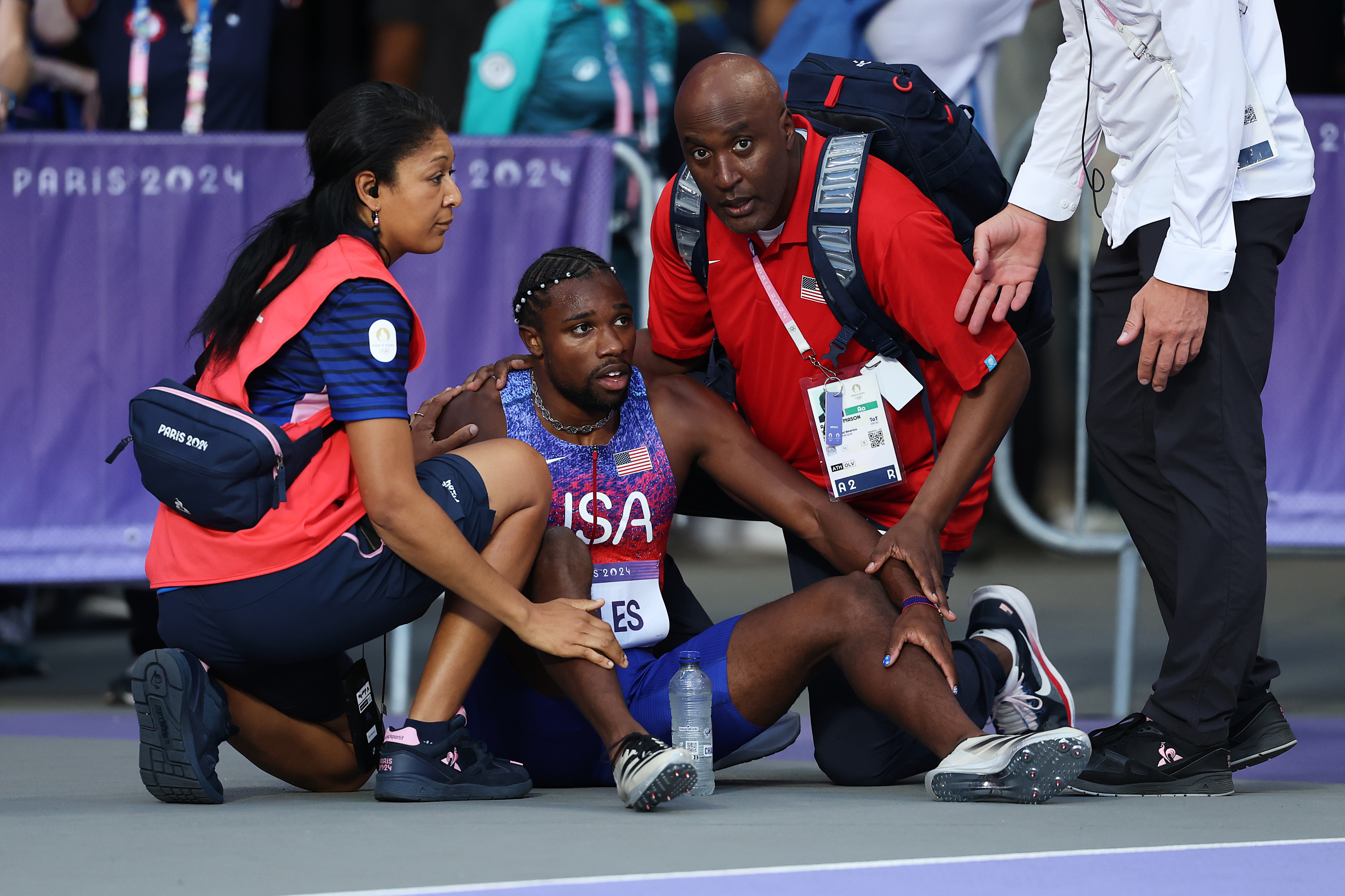 Noah Lyles of Team US being assisted by medical staff after competing in the Men's 200m Final at the Paris Olympic Games on August 8, 2024 | Source: Getty Images