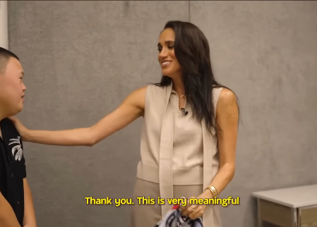 Meghan Markle accepts a gift from Sean and Marley. | Source: Facebook/HELLO! Canada