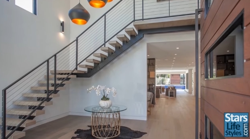 The grand entryway features soaring ceilings, a floating staircase, and an open-concept layout. | Source: YouTube/Stars Lifestyles