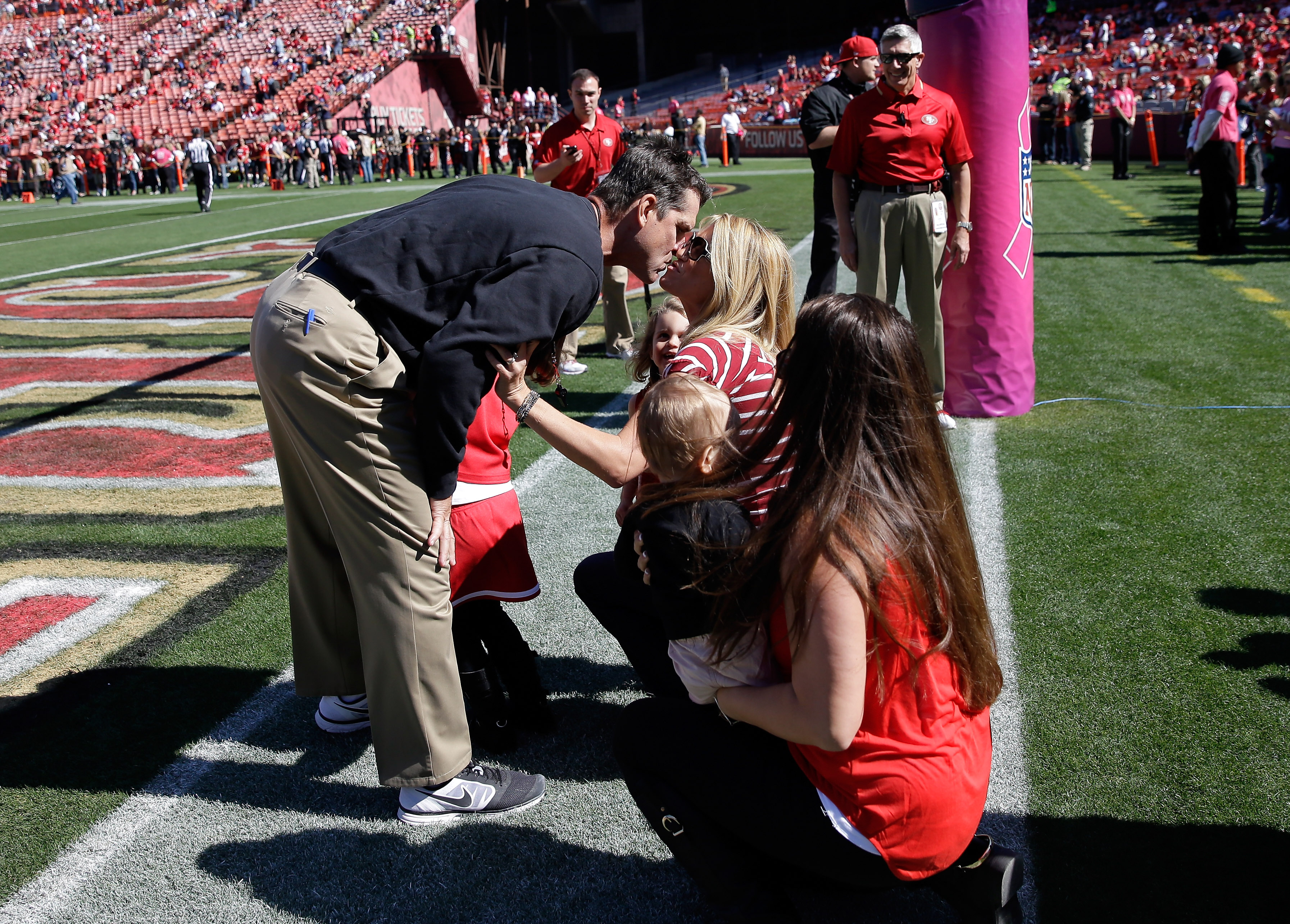 Jim Harbaugh kisses his wife Sarah Feuerborn Harbaugh before a game at Candlestick Park on October 13, 2013, in San Francisco, California | Source: Getty Images