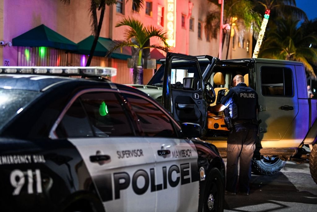 A police officer inspects the inside of a car on Ocean Drive in Miami Beach, on March 22, 2021 | Photo: Getty Images