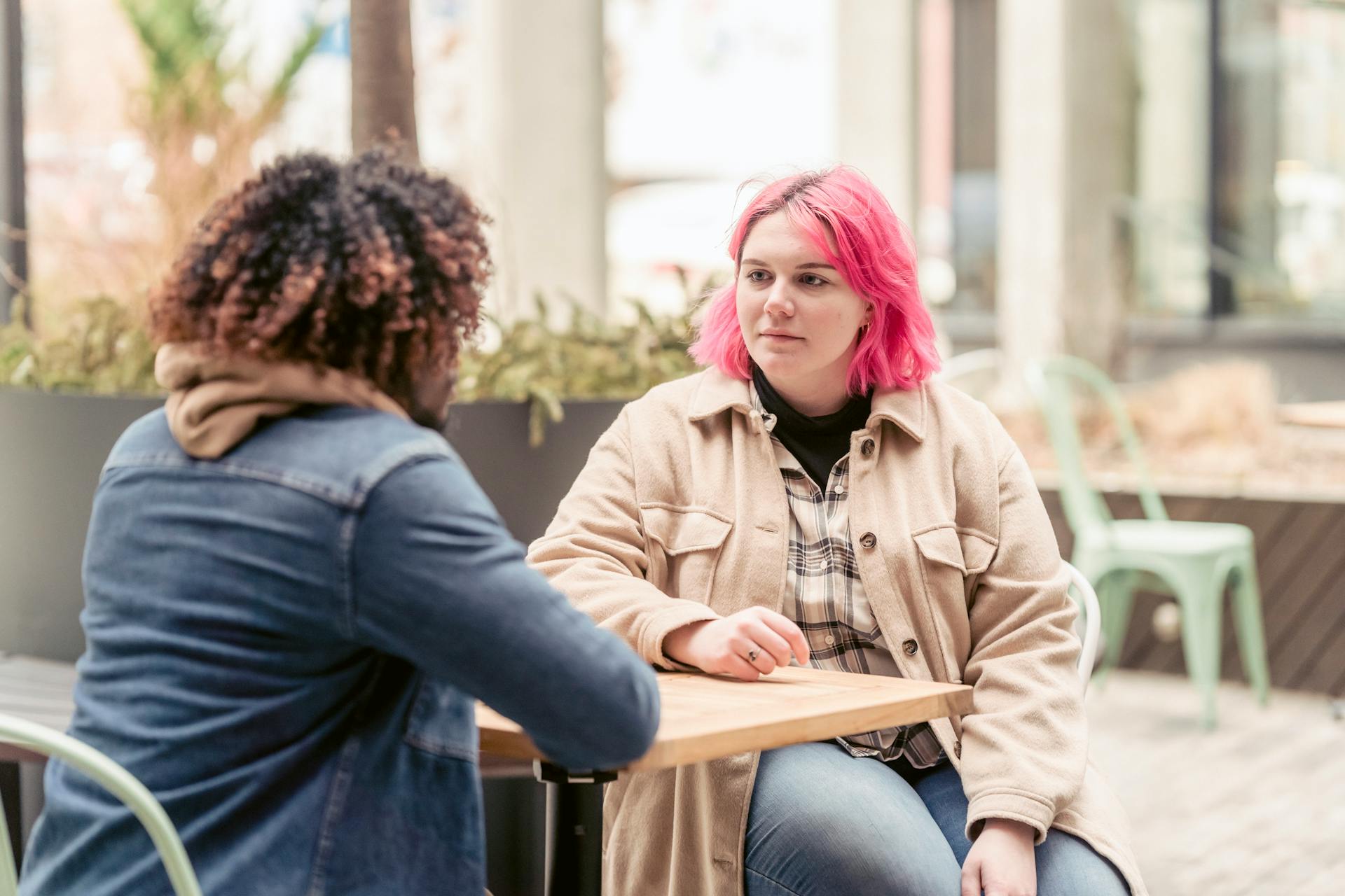 A woman listening to her friend while sitting in an outdoor café | Source: Pexels