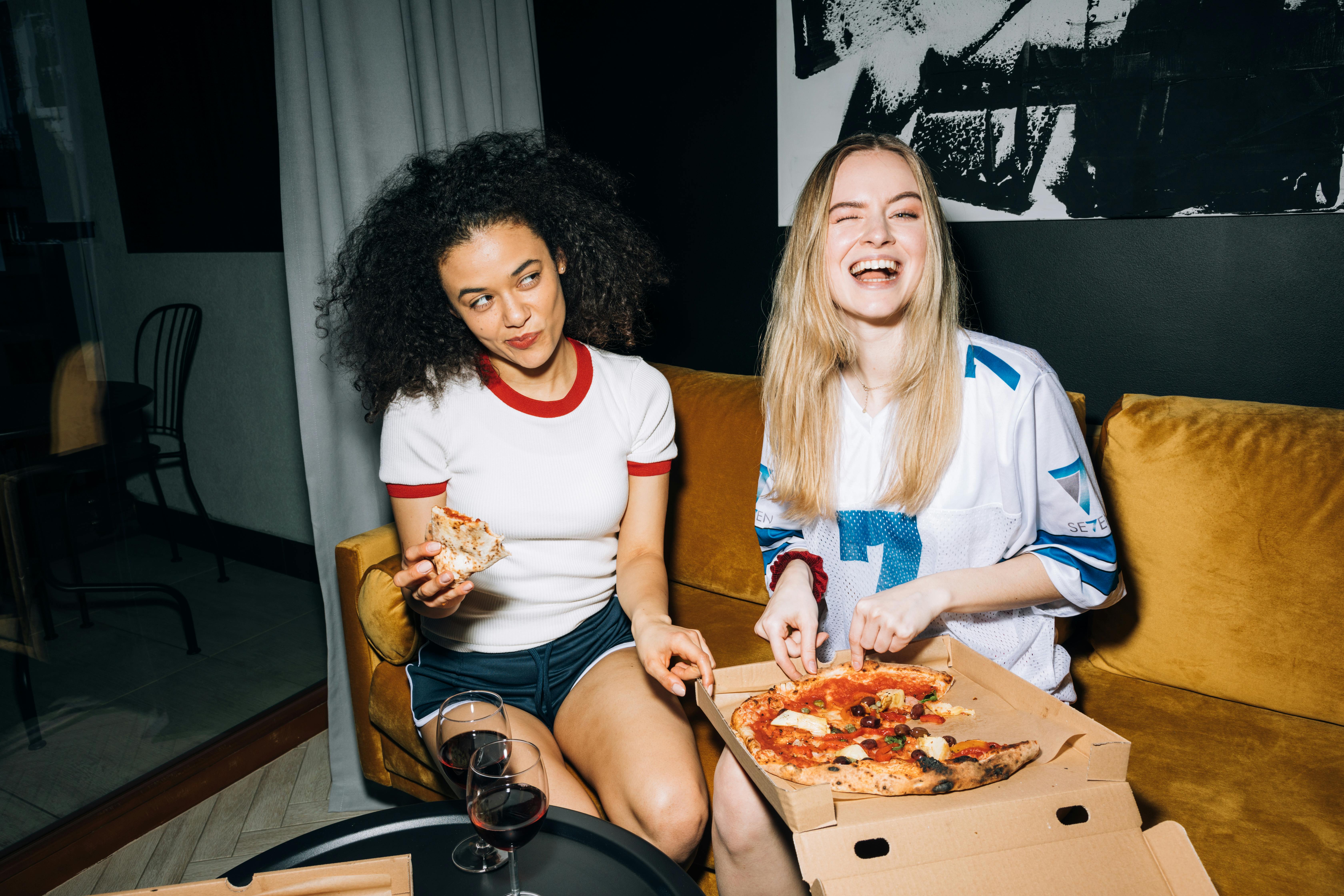 Two girls enjoying pizza | Source: Pexels