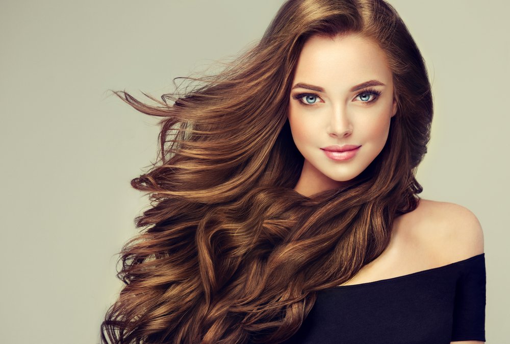 Brünette Frau mit langen und glänzenden gewellten Haaren | Quelle: Shutterstock