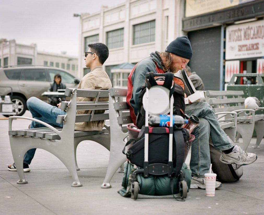 Indigente sentando en un banco. | Foto: Unsplash