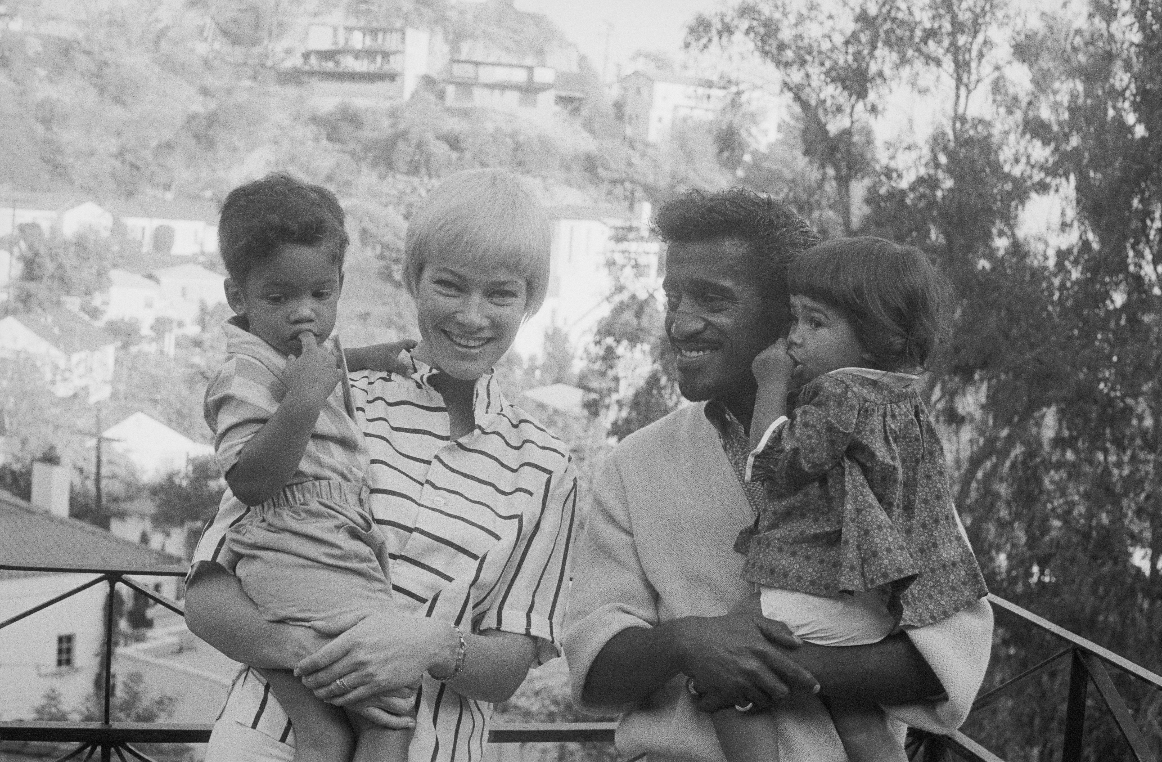 Sammy Davis, Jr., and his wife, actress May Britt, pose with their newly enlarged family in the garden of their home November 10th. | Source: Getty Images