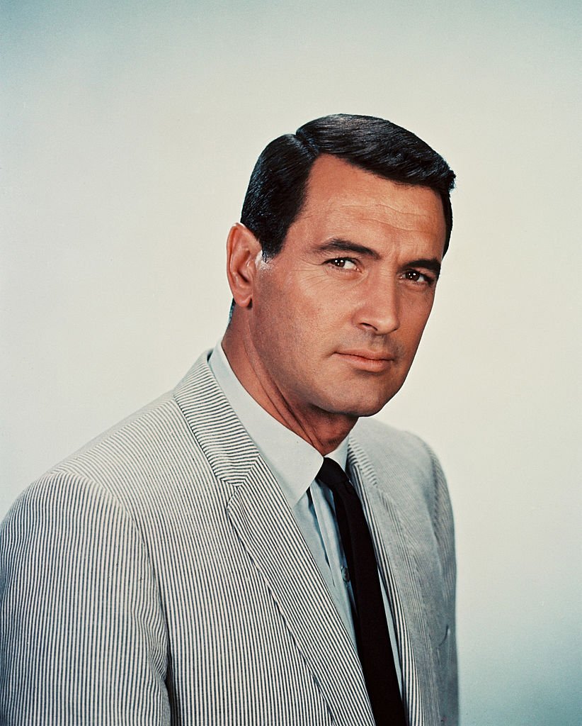 Rock Hudson wearing a black-and-white striped jacket, with a white shirt and a black tie, in a studio portrait, against a white background, circa 1960 | Photo: Getty Images