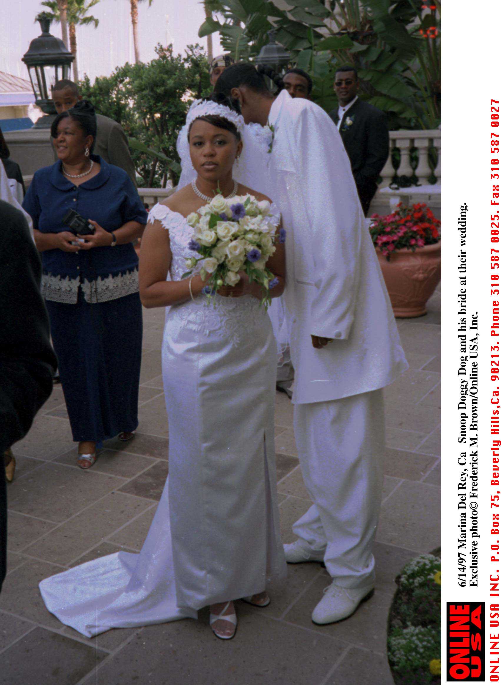 Snoop Dogg adjusts Shante's gown during their wedding at the Ritz Carlton Hotel on June 14, 1997 | Source: Getty Images