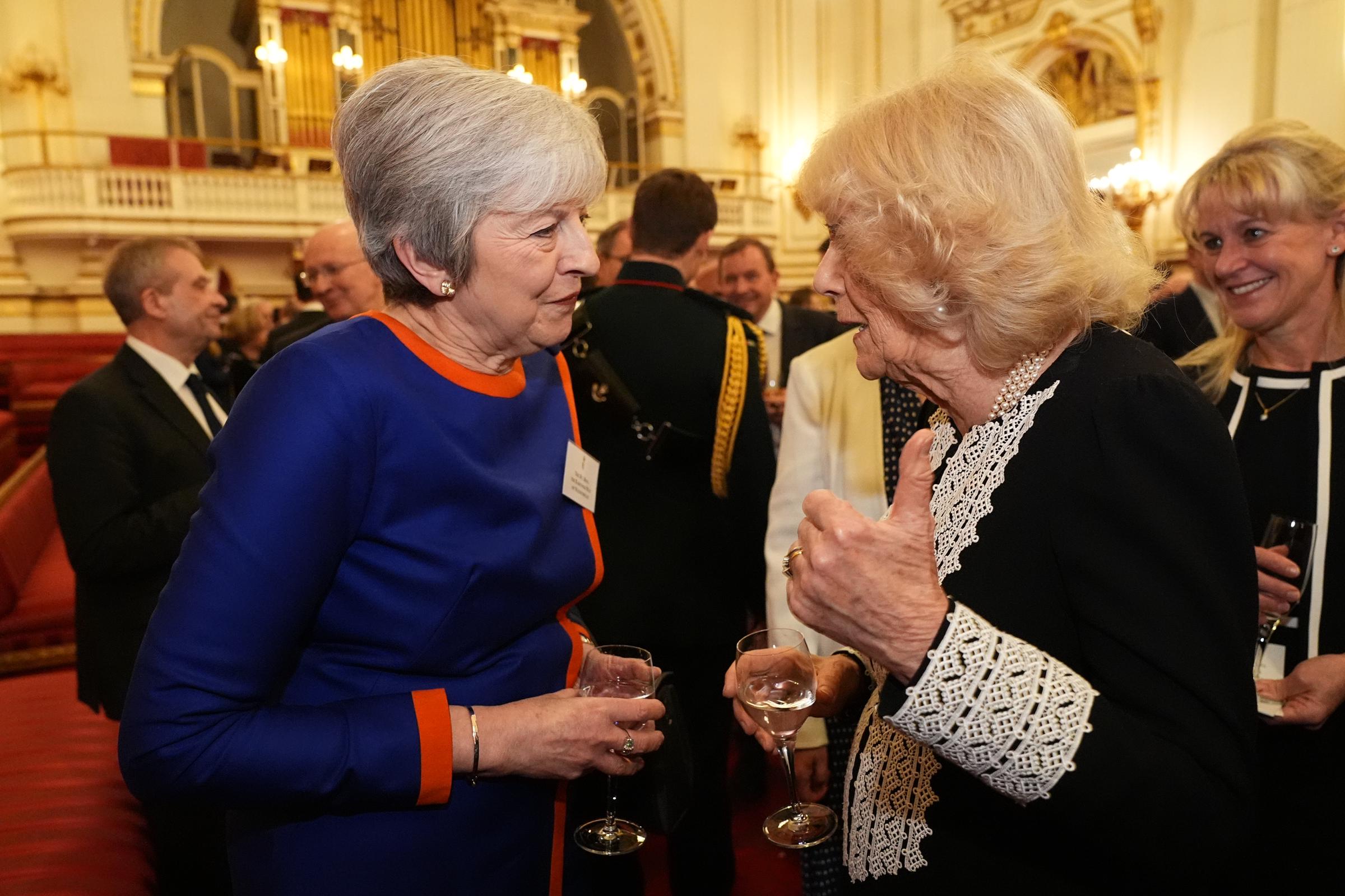 Queen Camilla speaks to former Prime Minister Theresa May at Buckingham Palace in England on January 29, 2025 | Source: Getty Images
