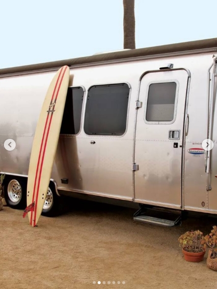 Matthew McConaughey's silver Airstream offered few clues from the outside that it had once functioned as the actor's home, workplace, and base for years of travel. A surfboard propped beside the aluminum trailer reflected another part of his laid-back lifestyle, while the compact entrance opened into the personalized space he called the Canoe. The image appeared in a post dated June 9, 2025. | Source: Instagram/ivd_ru