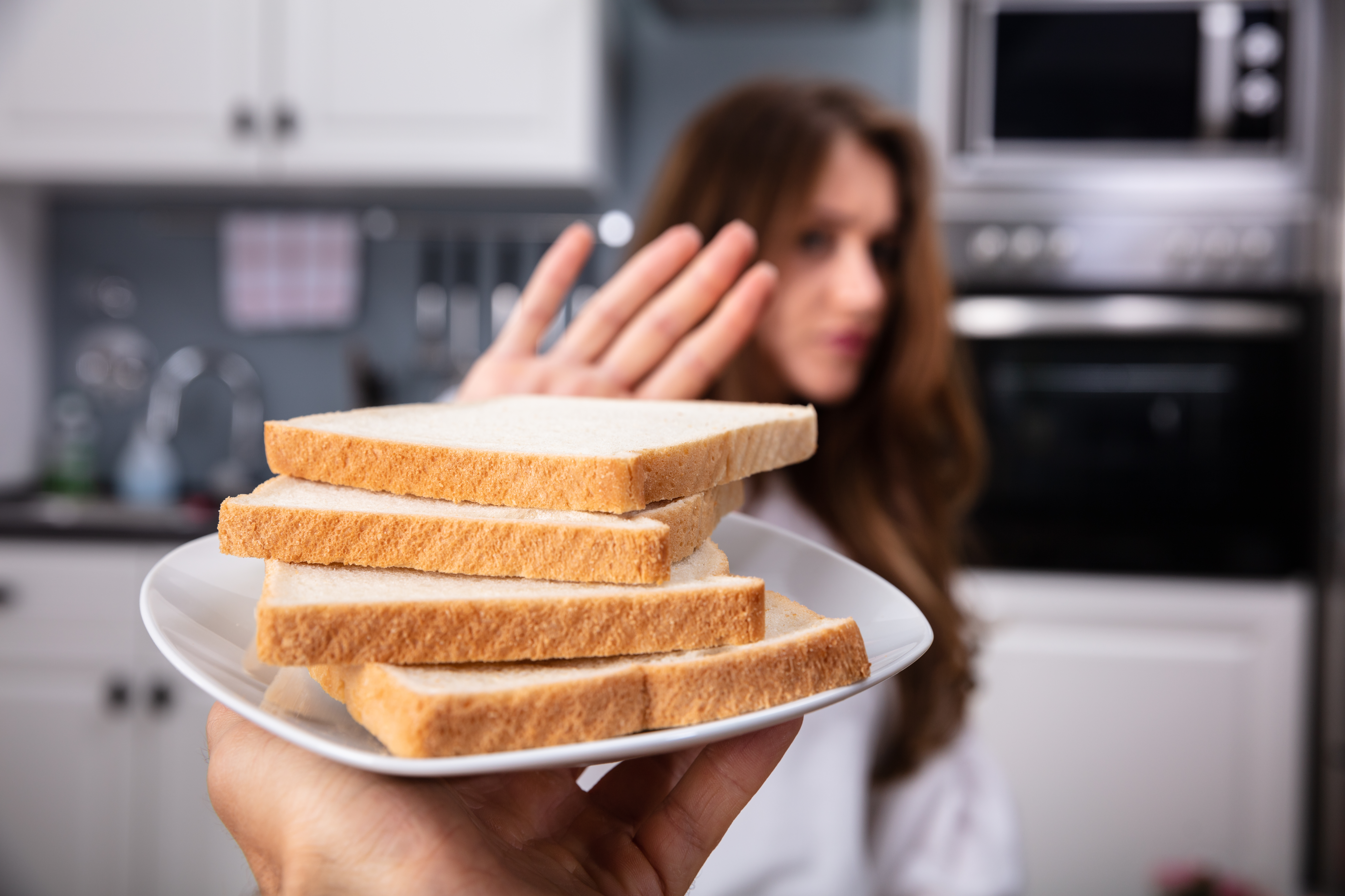A woman refusing a plate of white bread | Source: Shutterstock