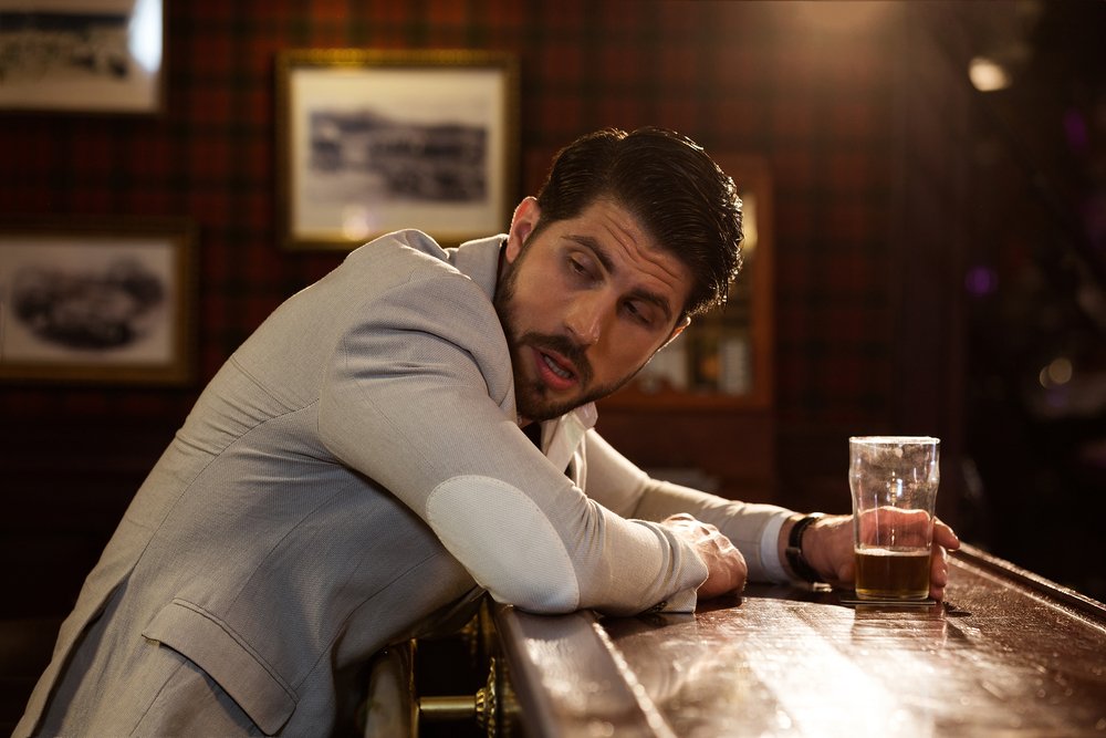 A man looking behind him in a bar. | Photo: Shutterstock