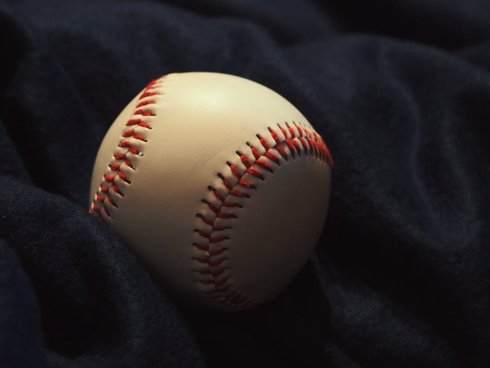 A photo of a baseball on a black blanket. | Photo: Pexels.