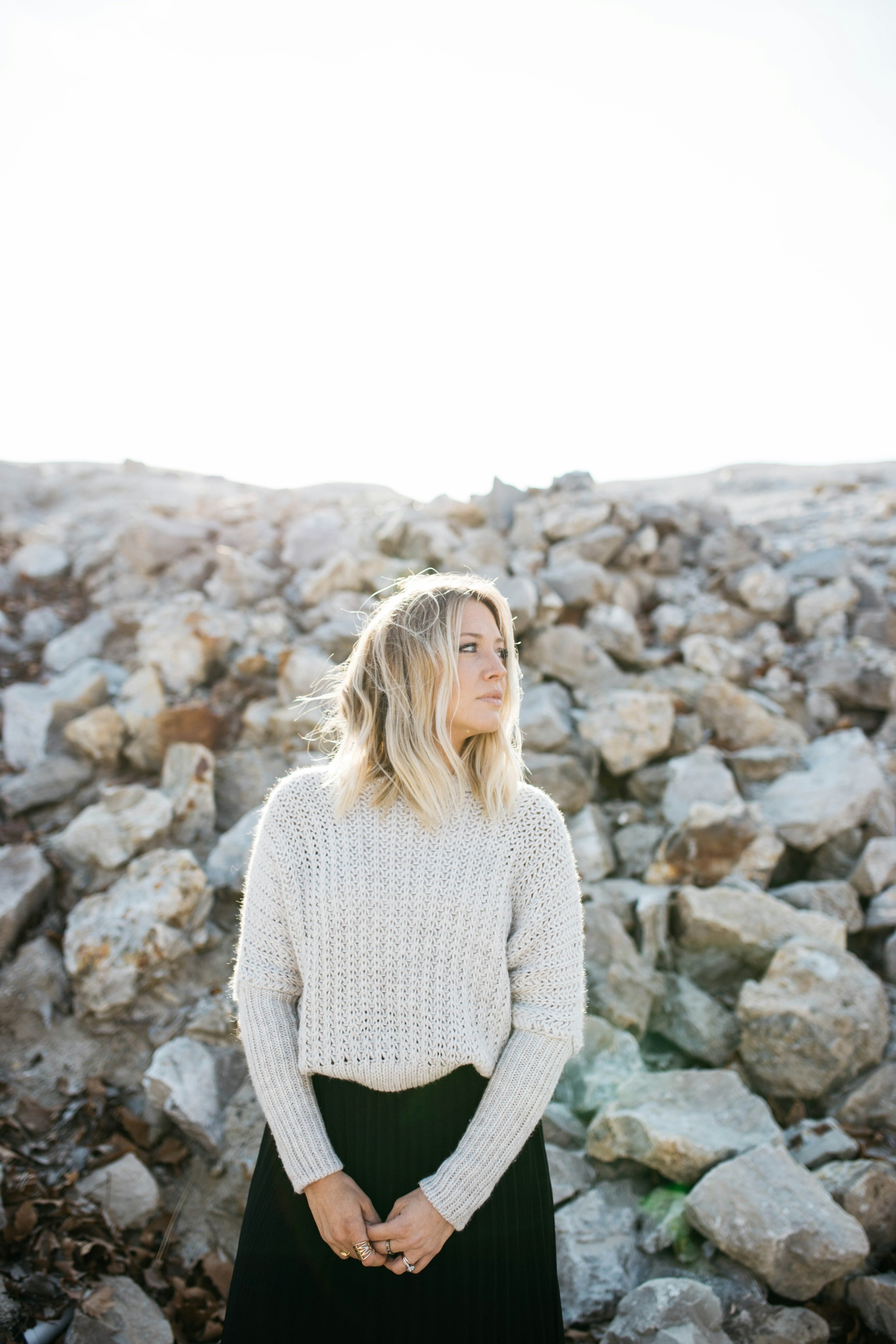 A blonde woman standing near a pile of stones | Source: Unsplash