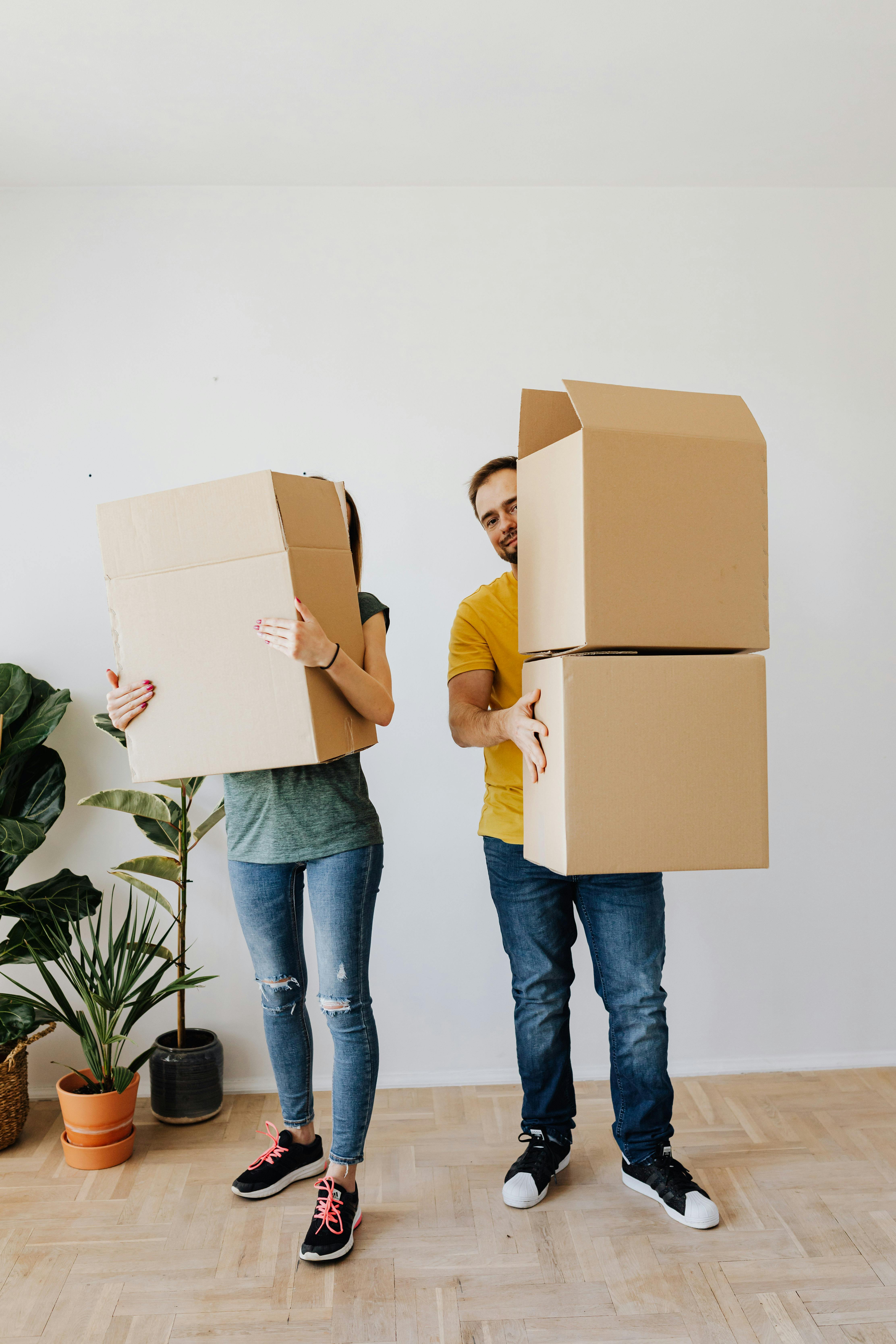 A couple holding boxes ready to move | Source: Pexels