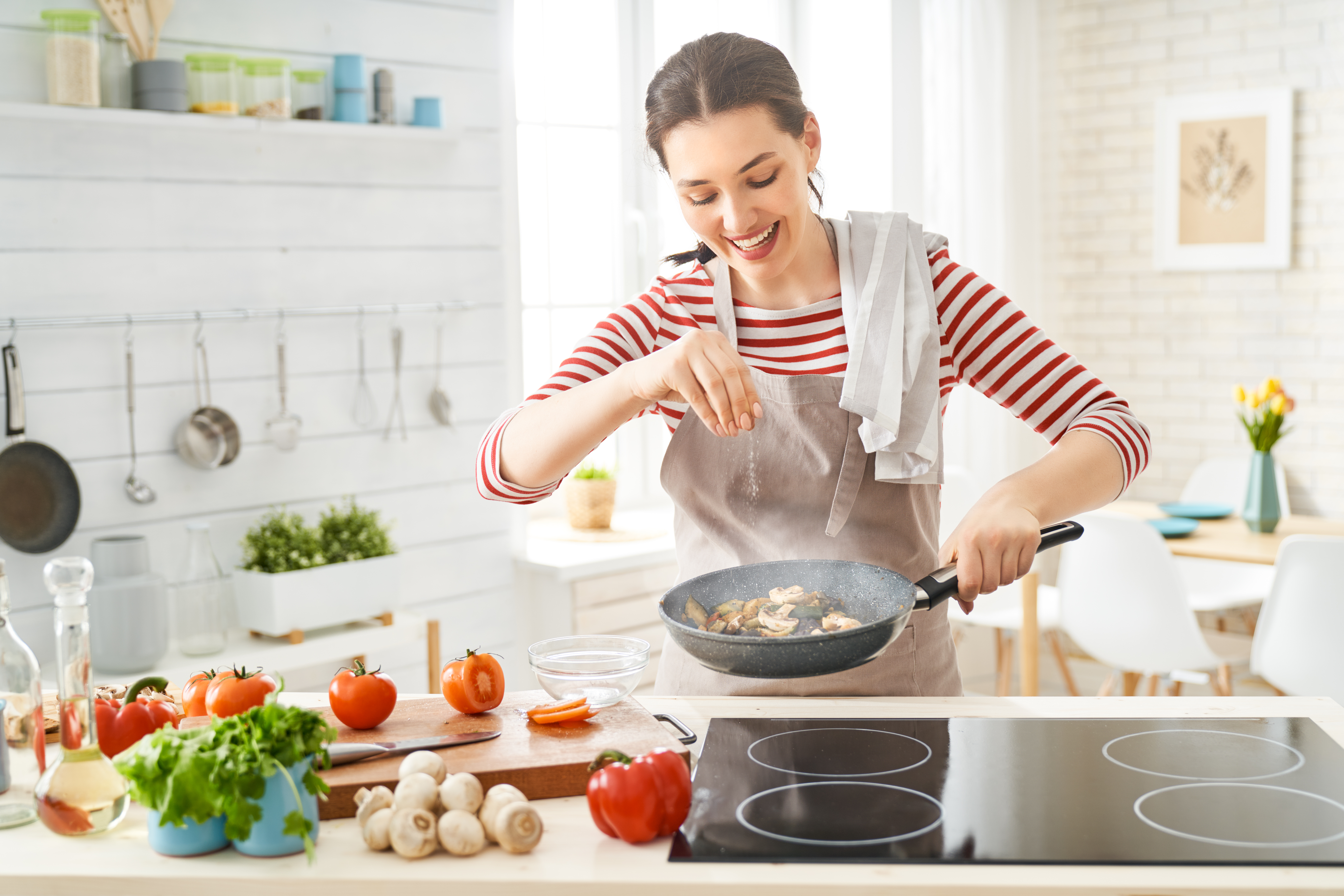 Happy woman is preparing the proper meal in the kitchen. | Source: Shutterstock