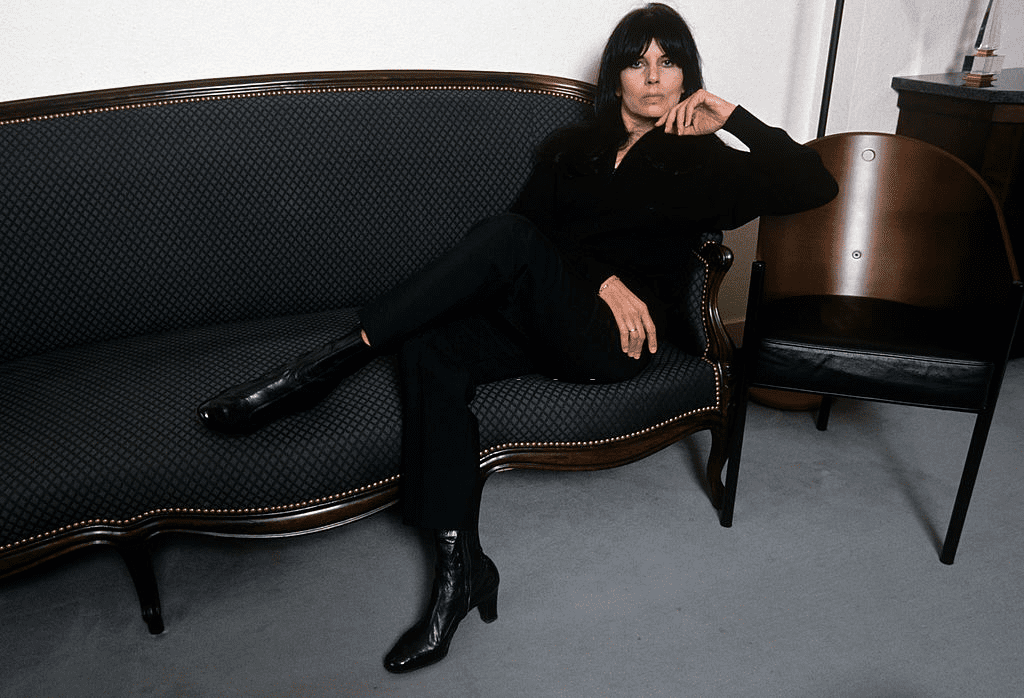 Les idoles des années 60 : Catherine Ribeiro chez elle. À Charleville -Mezières, Catherine RIBEIRO chez elle quelques minutes avant sa tentative de suicide, de noir vêtue, assise sur son divan. | Photo : Getty Images