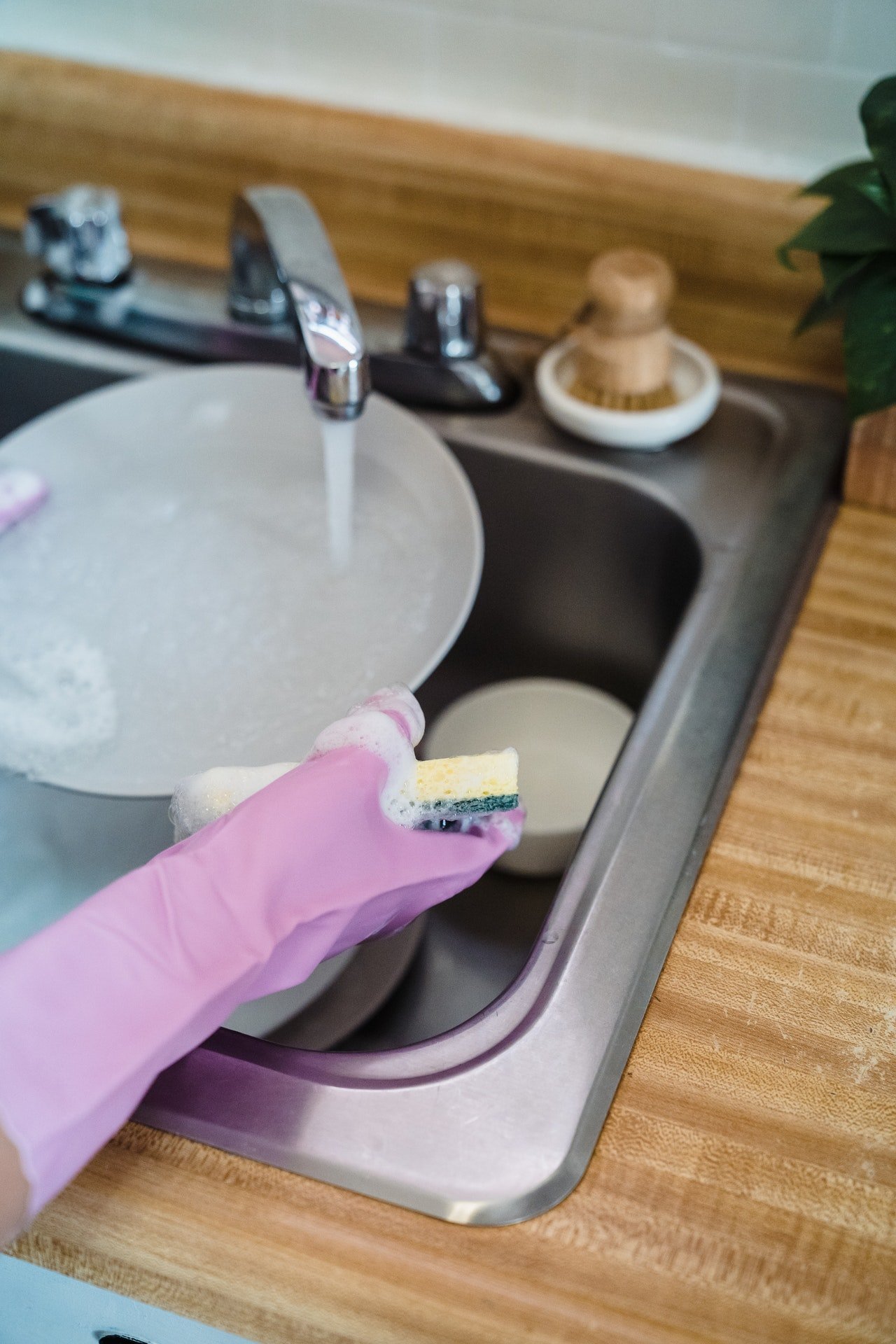 Persona lavando platos. | Foto: Pexels