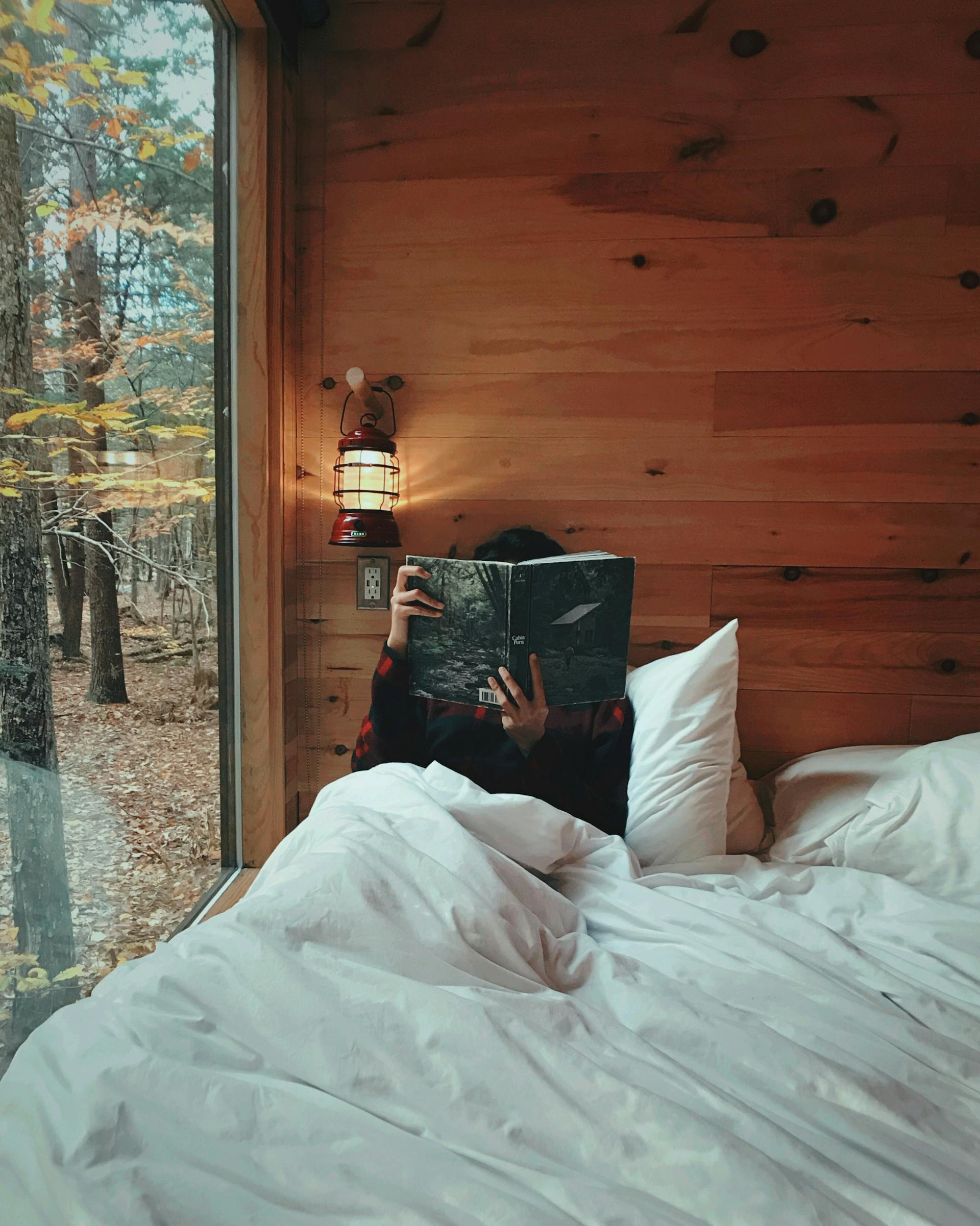 A person sitting in bed in a cabin | Source: Pexels