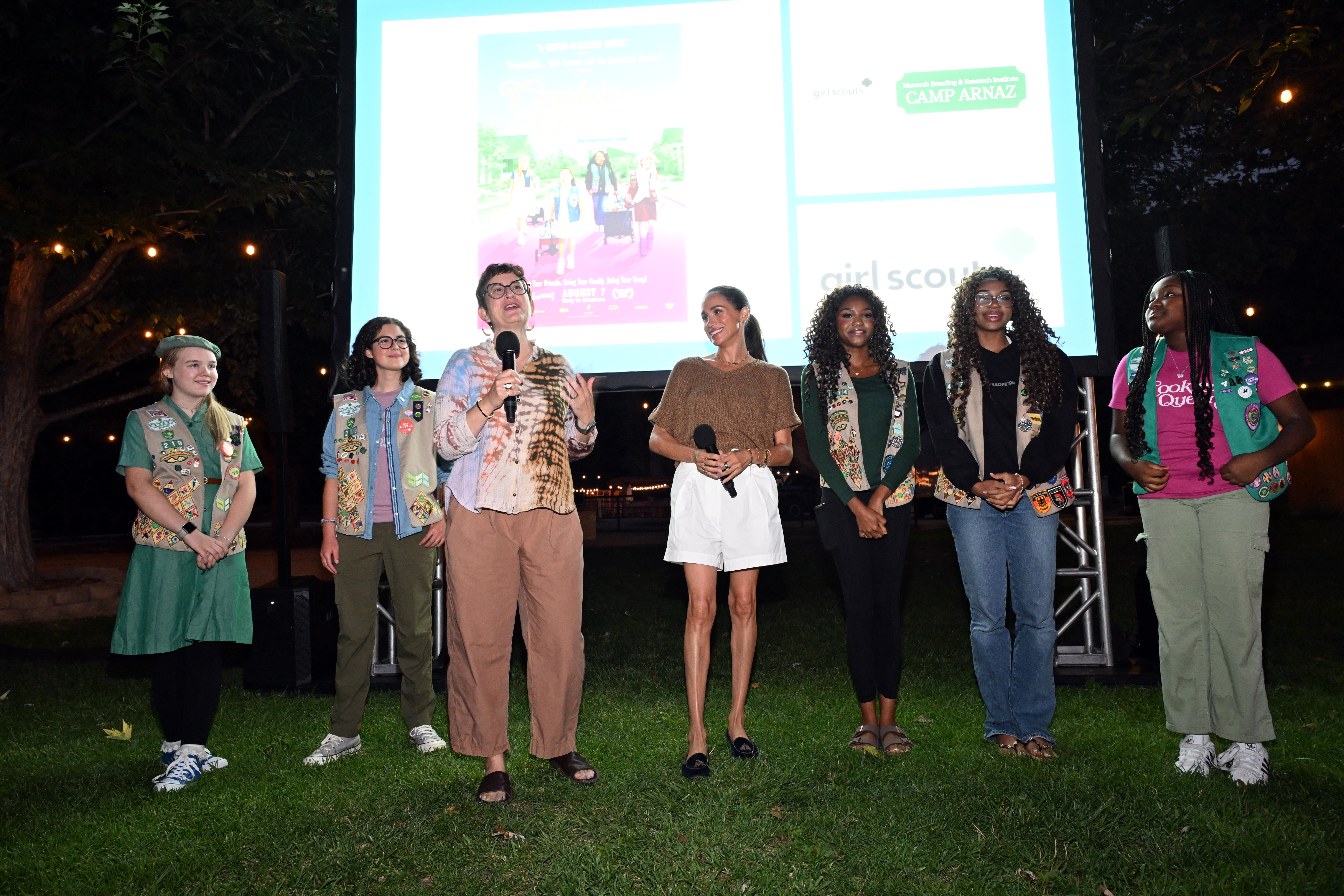Filmmaker Alysa Nahmias addresses attendees alongside Meghan Markle and Girl Scouts whose stories are featured in Cookie Queens, which opens in theaters on August 7. | Source: Getty Images
