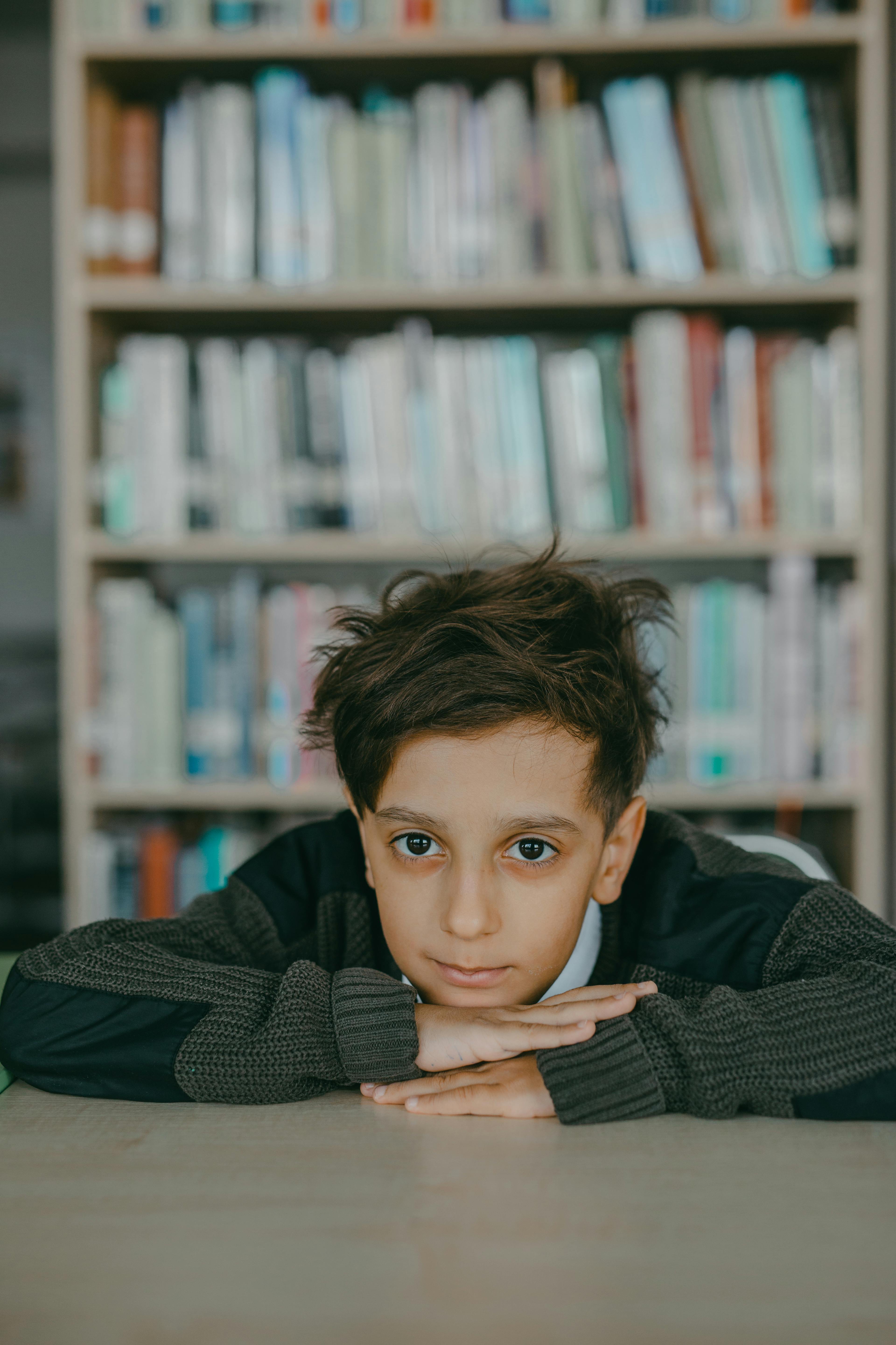 A boy leaning on a desk | Source: Pexels