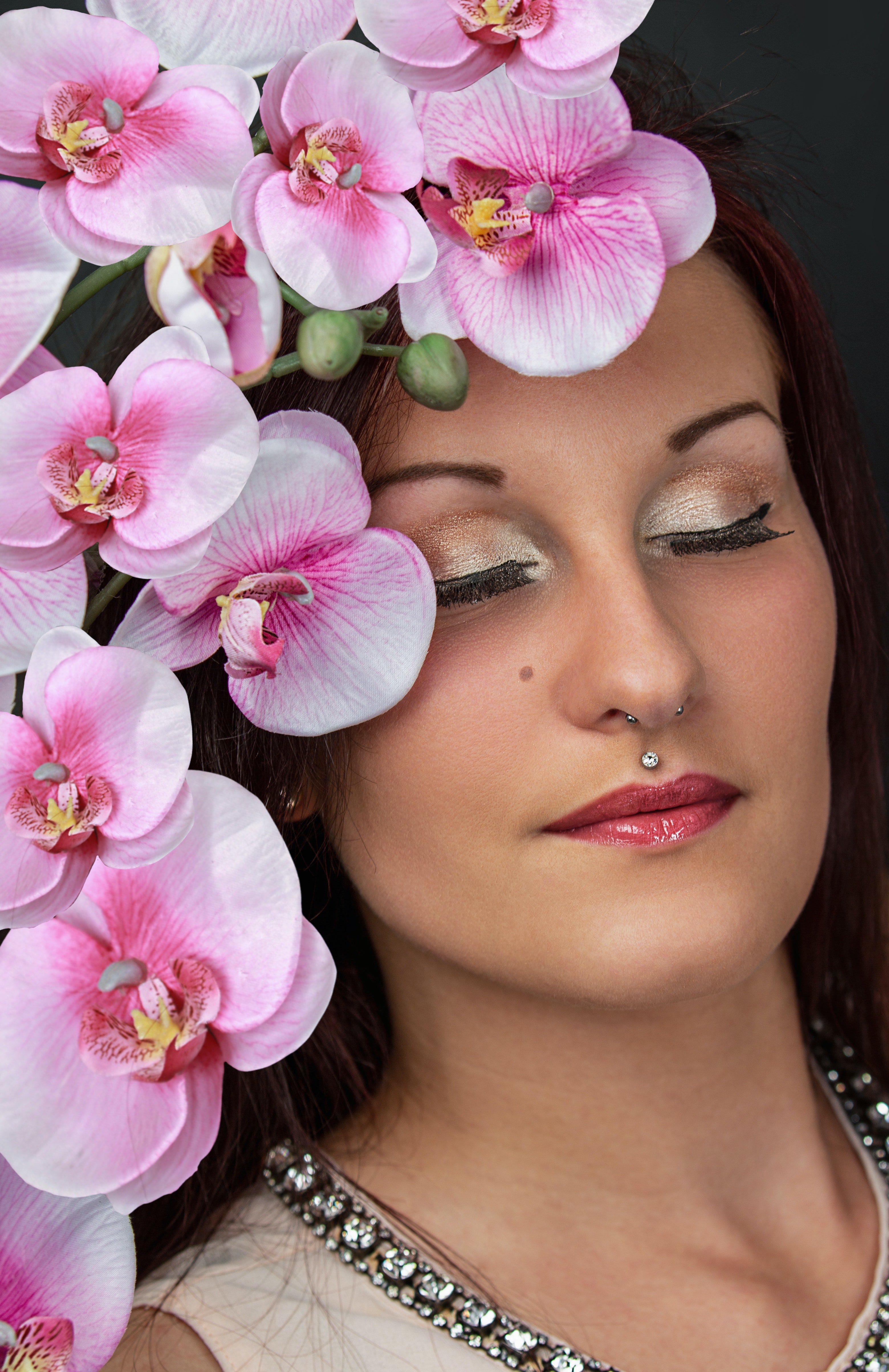 Woman with Medusa piercing and pink orchids hair decoration | Source: Pexels.com/Antonio Friedemann
