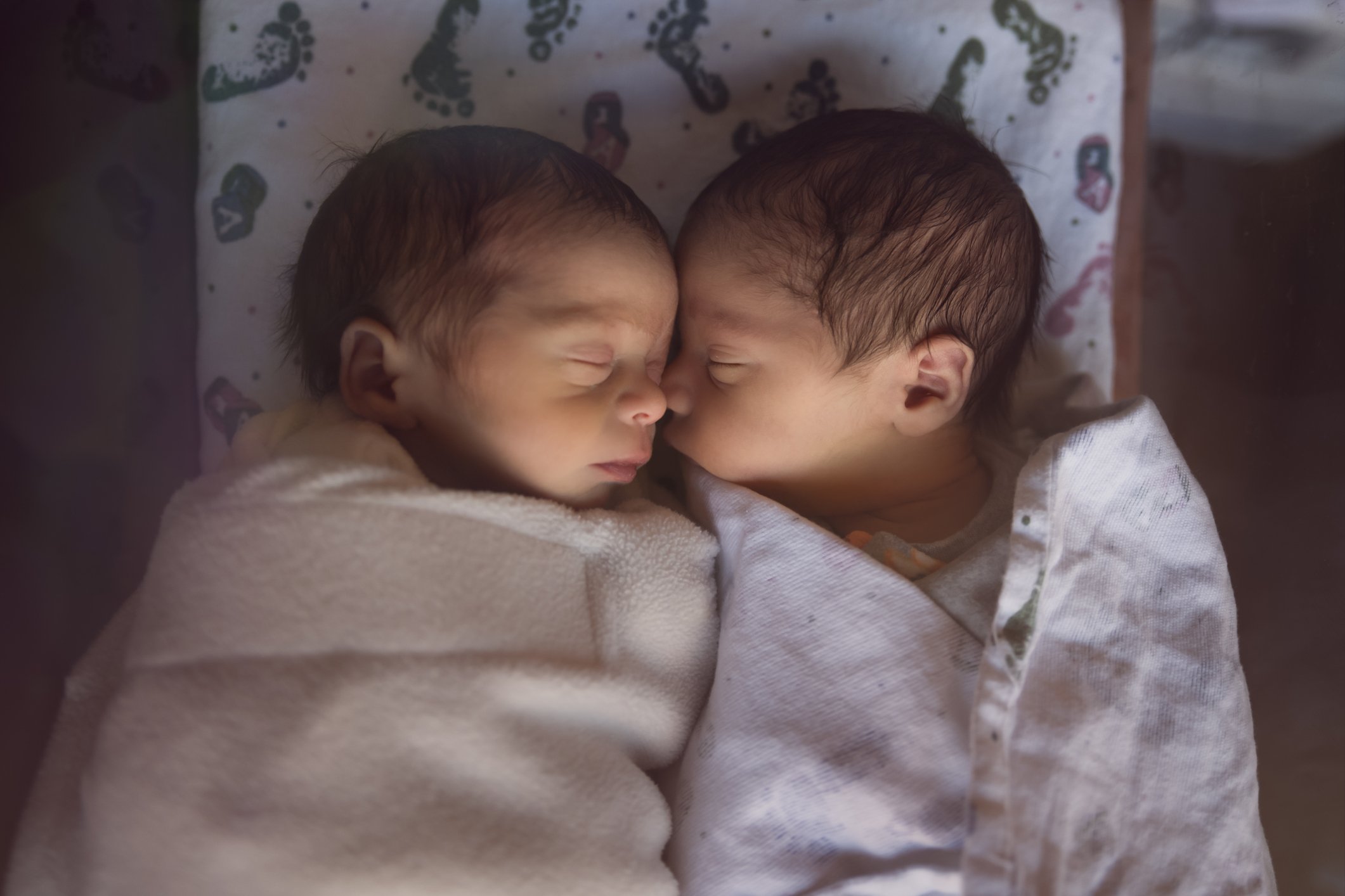 Premature Newborn Fraternal Twins in Hospital Sleep Together in Plastic Crib | Photo: Getty Images