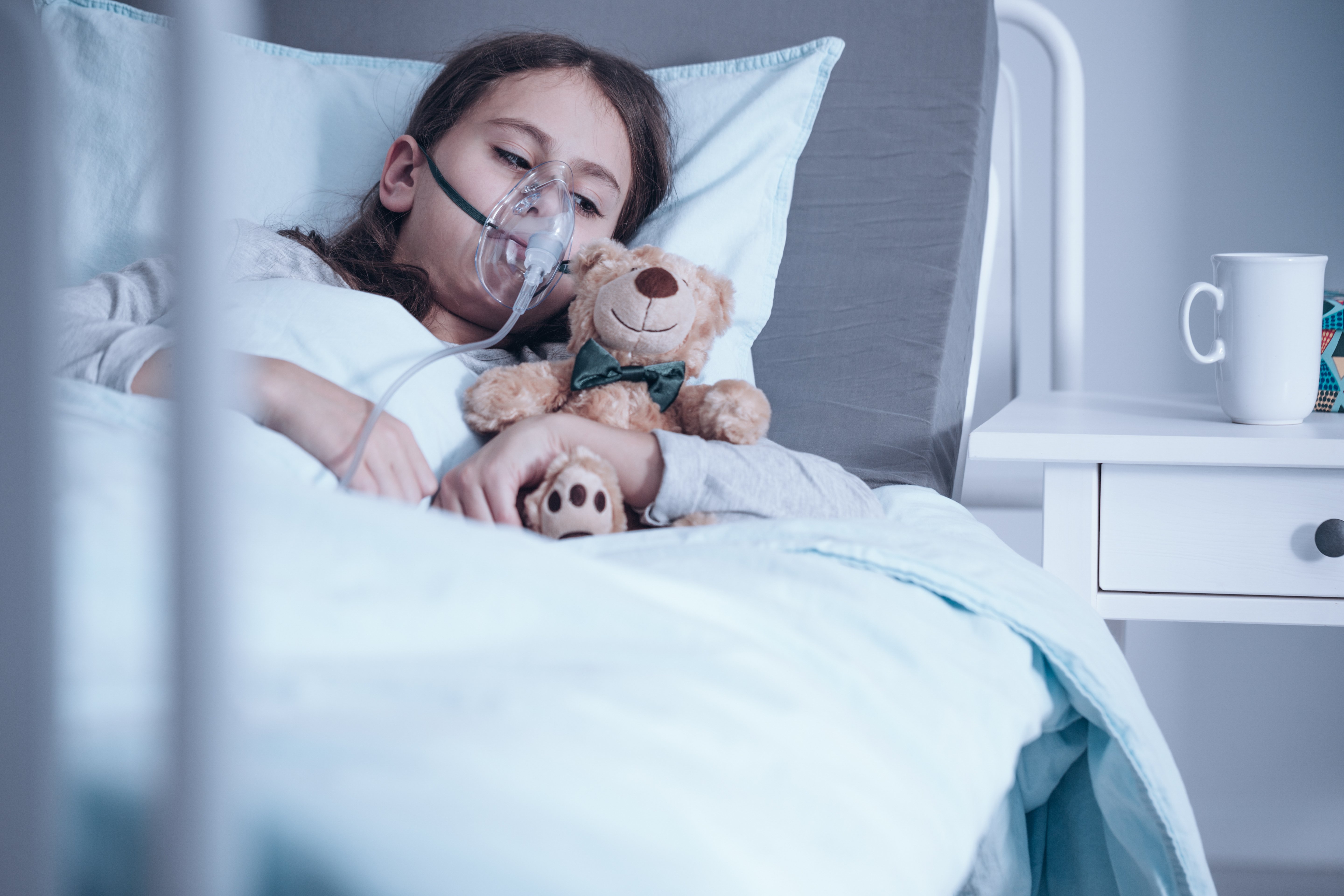 Ein krankes kleines Mädchen im Krankenhaus mit ihrem Teddybären. | Quelle: Shutterstock