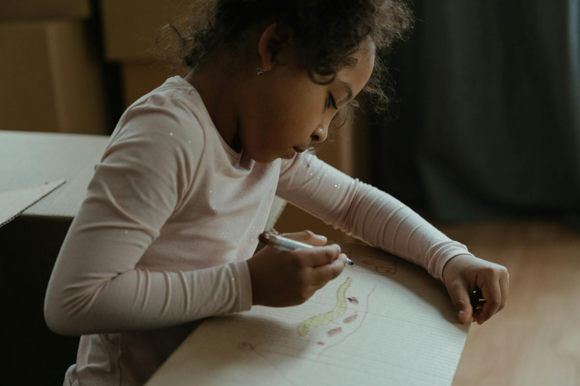 Child drawing on a box | Source: Pexels