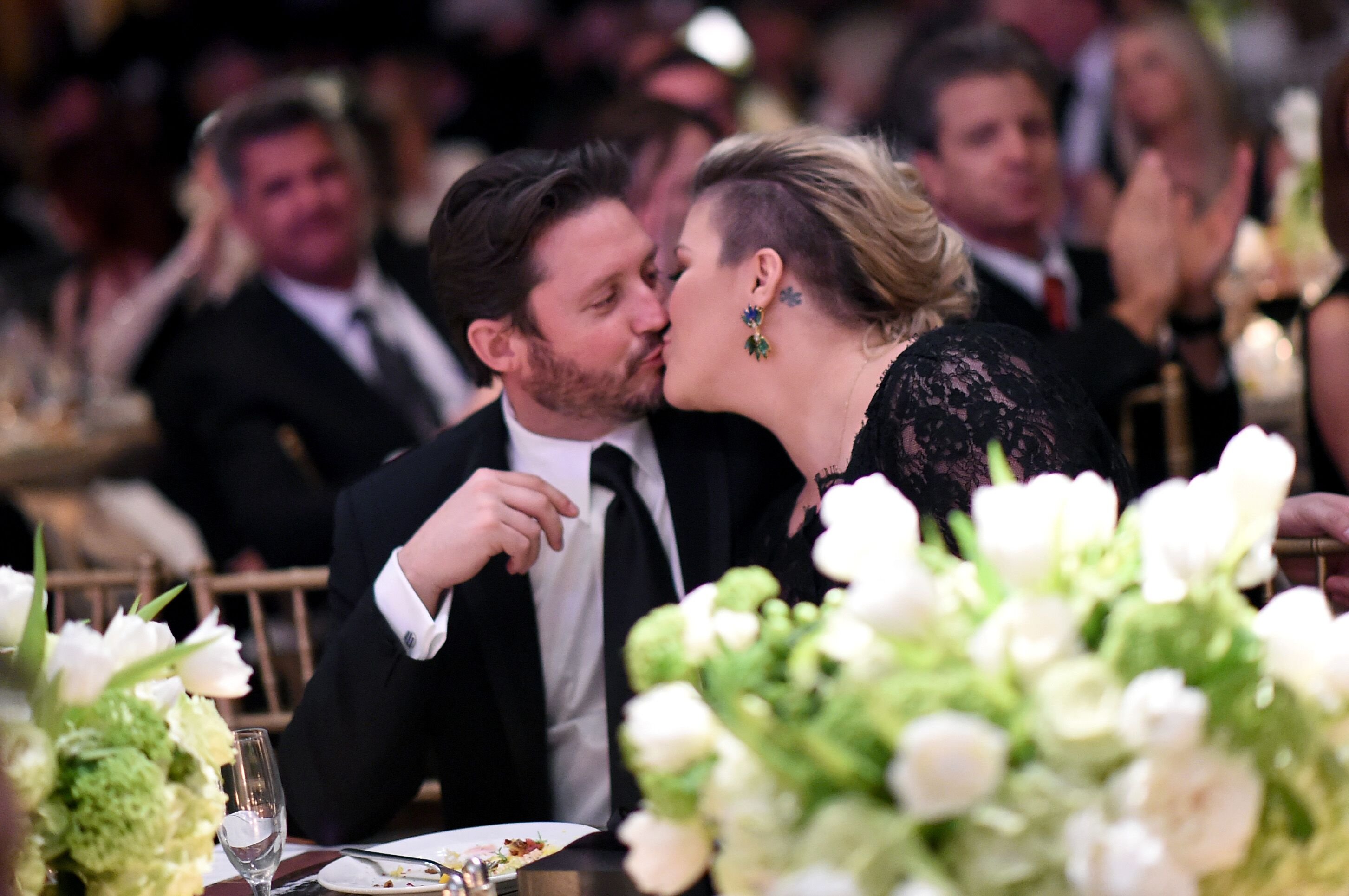 Brandon Blackstock and wife Kelly Clarkson share a kiss at Muhammad Ali's Celebrity Fight Night XXI at the JW Marriott Phoenix Desert Ridge Resort & Spa on March 28, 2015 | Photo: Getty Images