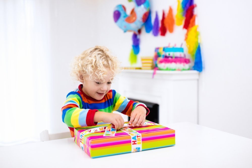 A young boy opening his birthday presents. | Photo: Shutterstock