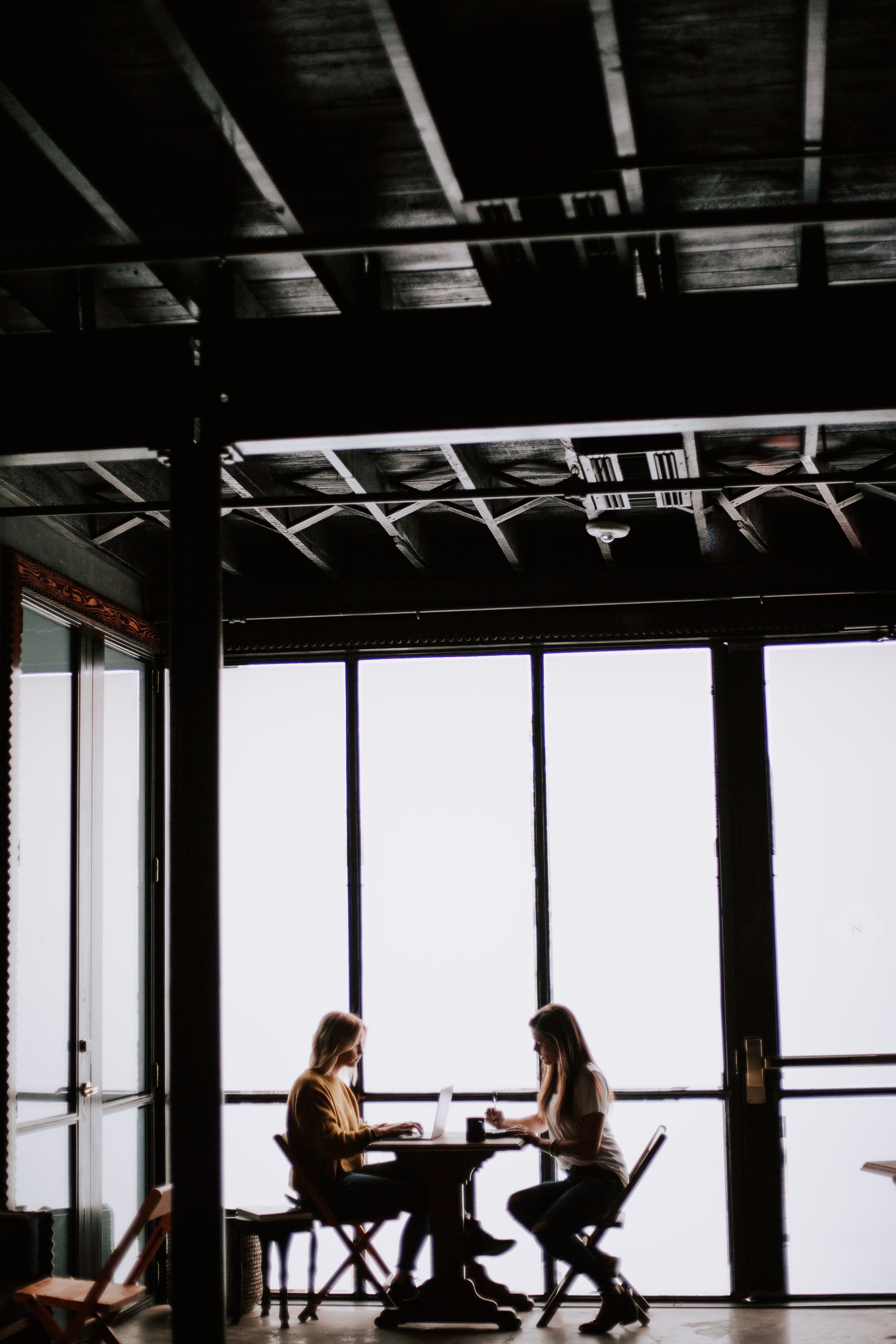 Two young women talking in a café | Photo: Unsplash