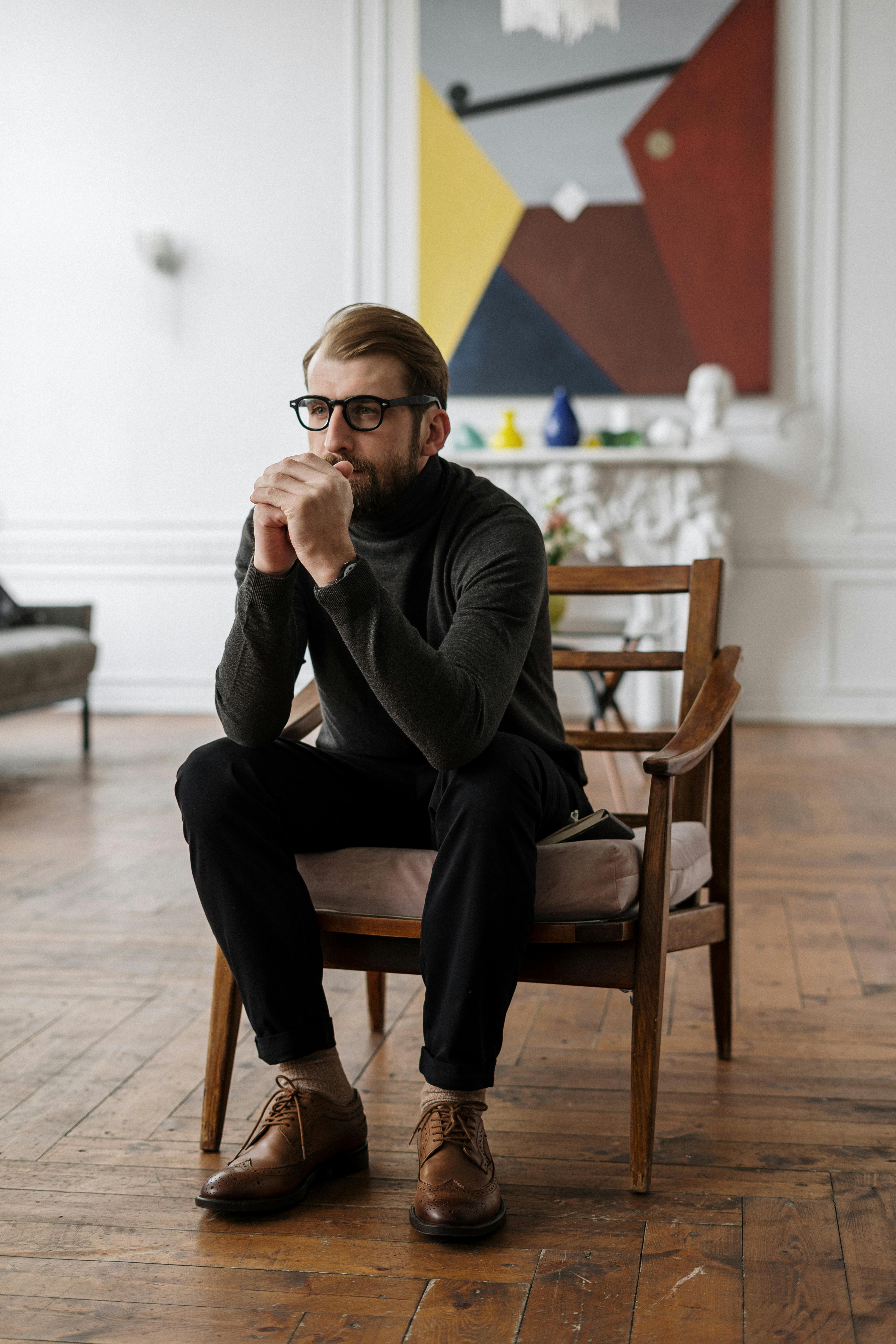 A man looking pensive seated on a chair | Source: Pexels